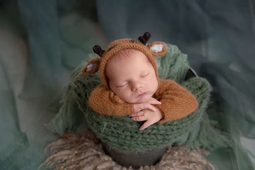Newborn portrait session capturing the delicate beauty of a baby’s first days with soft blankets and gentle posing.