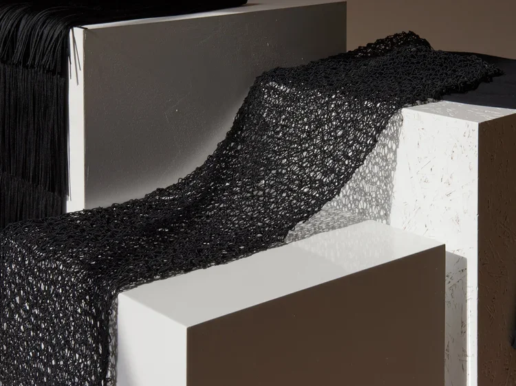 
Mesh Tubular Knit Textile | 18.01LONDON Fashion Archive

Black open mesh tubular knit textile draped across sculptural display plinths.

Experimental tubular knit textile exploring transparency, engineered mesh construction and innovative fabric dev