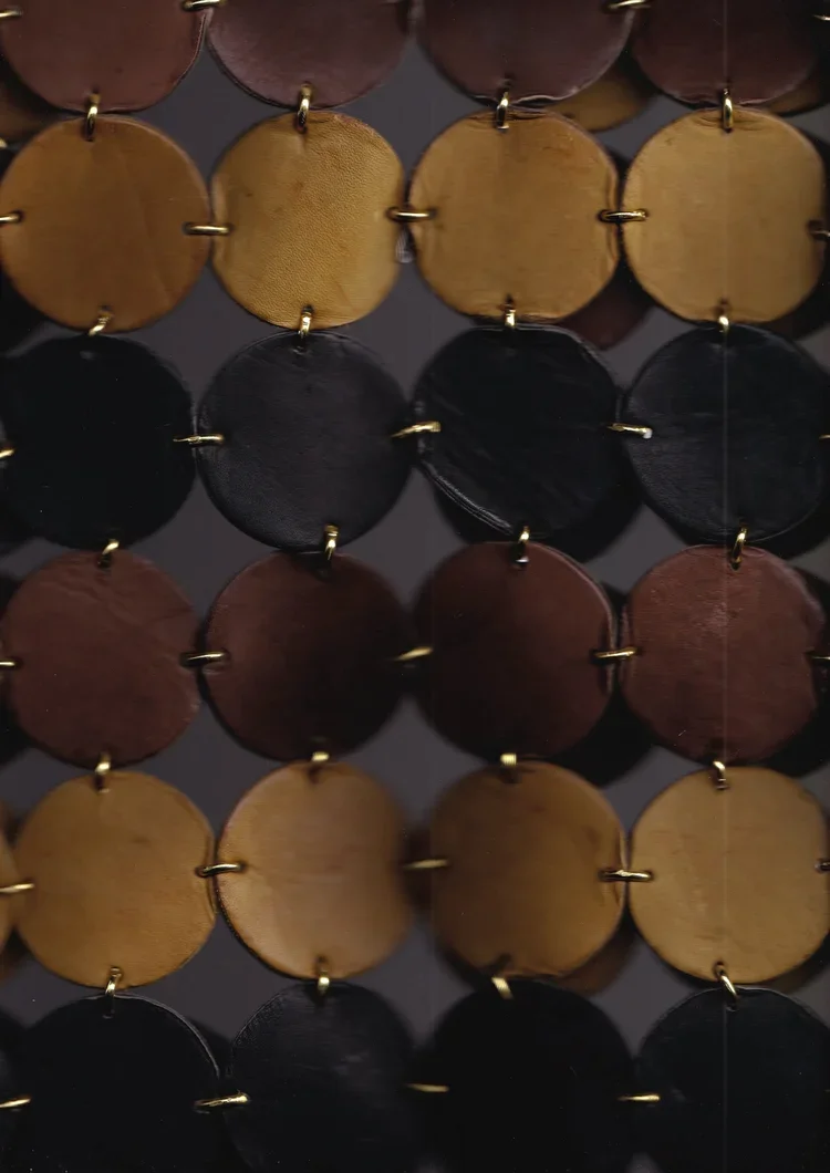 
Paco Rabanne Leather Disc Construction Detail | Fashion Research Archive London
Close-up of a Paco Rabanne leather disc construction featuring individually linked circular leather panels joined with metal rings.
An archival detail highlighting Paco 