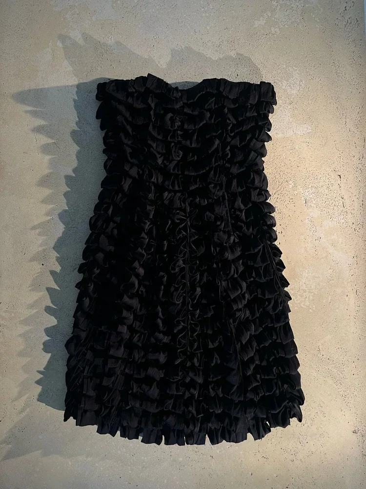 
Yves Saint Laurent Ribbon Dress | Fashion Research Archive London
Black Yves Saint Laurent dress covered in layered ribbon ruffles creating sculptural texture.
A richly textured Yves Saint Laurent dress constructed from densely layered ribbon applic