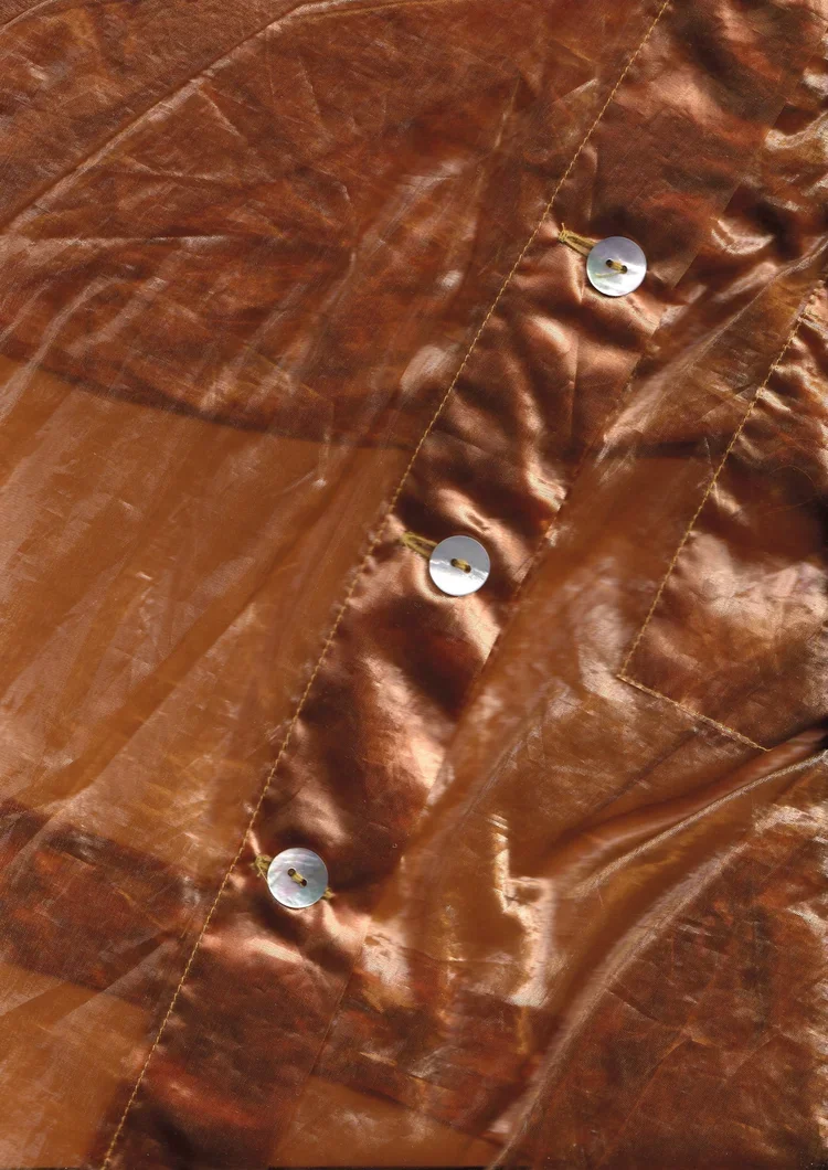 Reflective Organza Minimal Shirt | 1990s Fashion Archive

Transparent organza shirt with reflective copper finish and pearl buttons.

Minimalist 1990s organza shirt featuring reflective textiles, transparent construction and refined tailoring from th