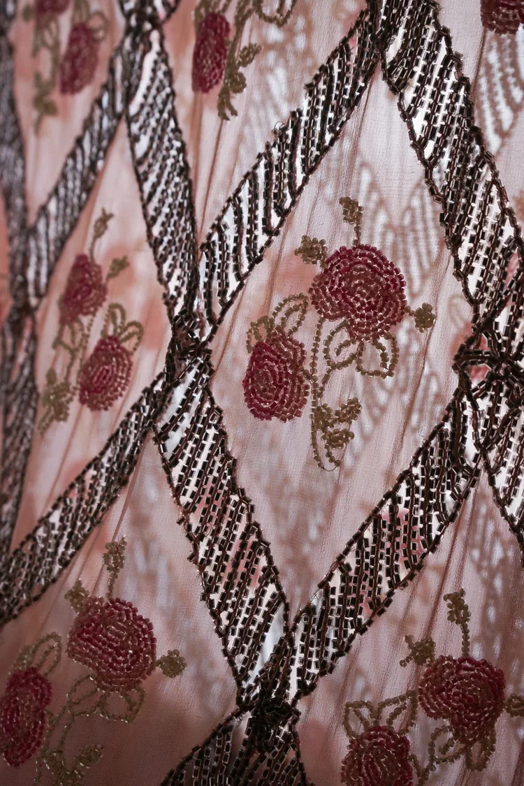 1920s Beaded Flapper Dress Detail | 18.01LONDON Fashion Archive

Close-up of a 1920s flapper dress featuring geometric beadwork and floral embroidery.

Art Deco beadwork combining geometric embellishment with delicate floral embroidery, preserved wit