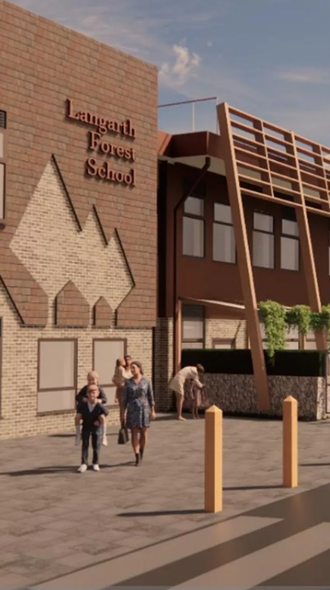 The exterior of Langarth Forest School with a brick and wooden building, people walking outside, including a woman and children, and a mural of mountains on the brick wall.