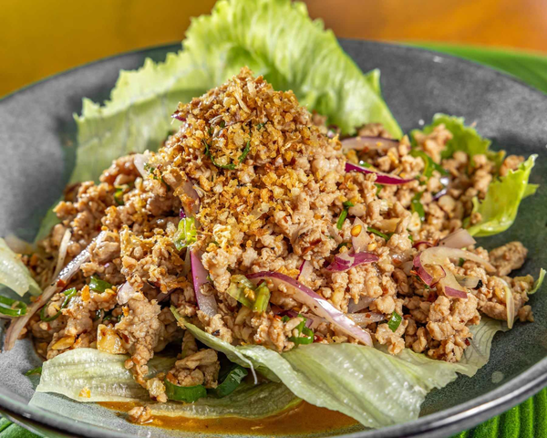 Ground meat salad with chopped vegetables, lettuce, and crushed peanuts in a black bowl. Kaia's Kitchen Harristown