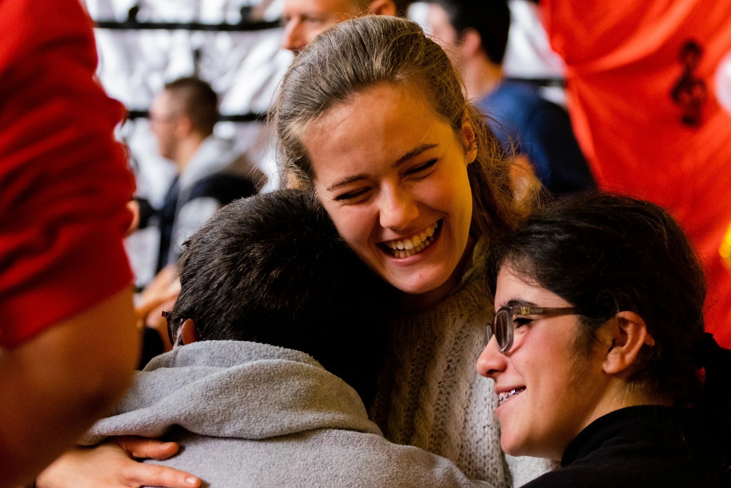 grupo de personas riendo y abrazándose en un ambiente social.