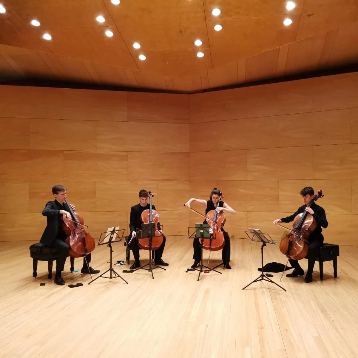Cuarteto de cuerdas tocando en un escenario de madera