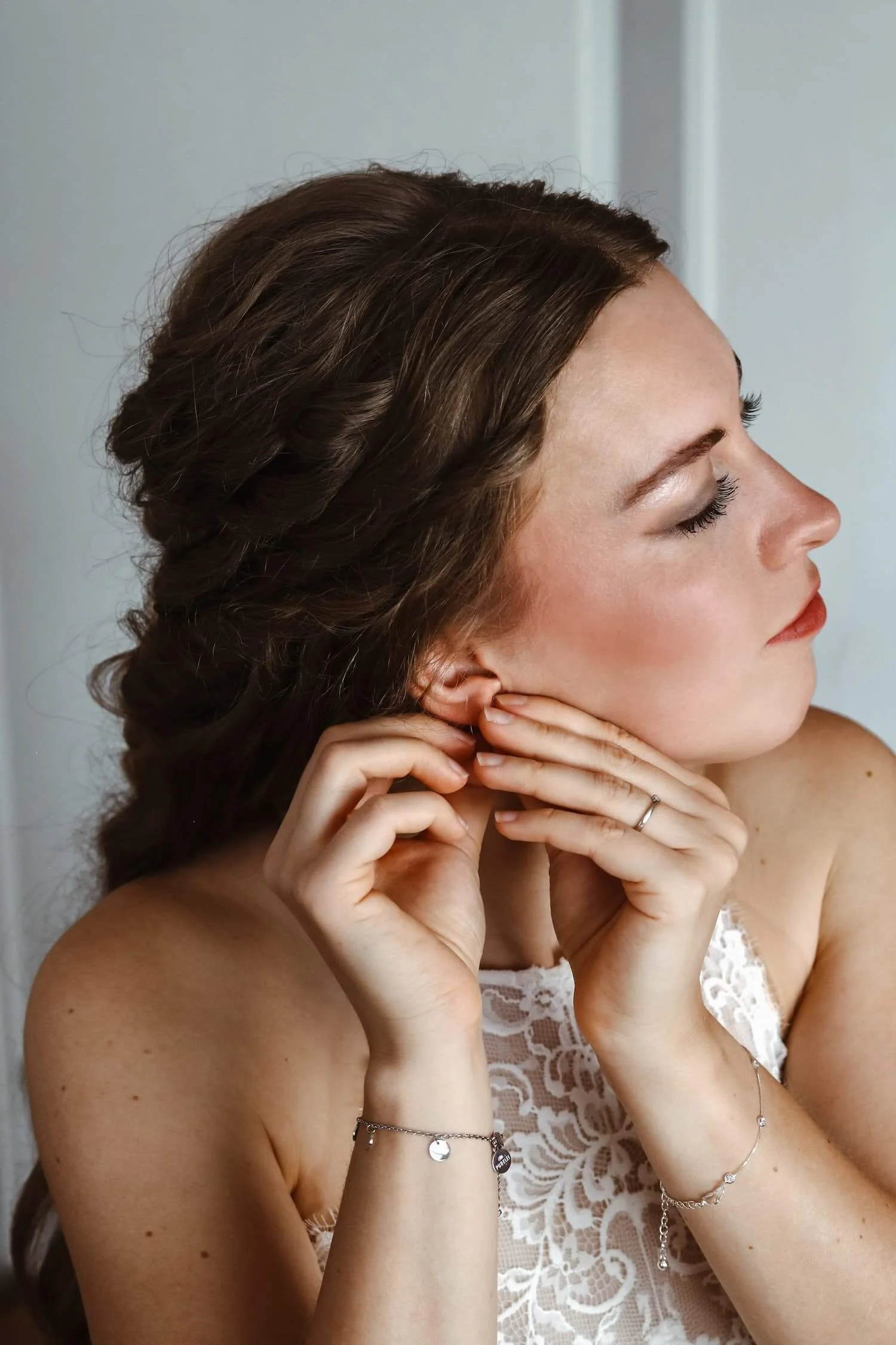 Braut steckt sich Ohrringe an, elegantes Getting-Ready-Foto in Ochsenhausen.