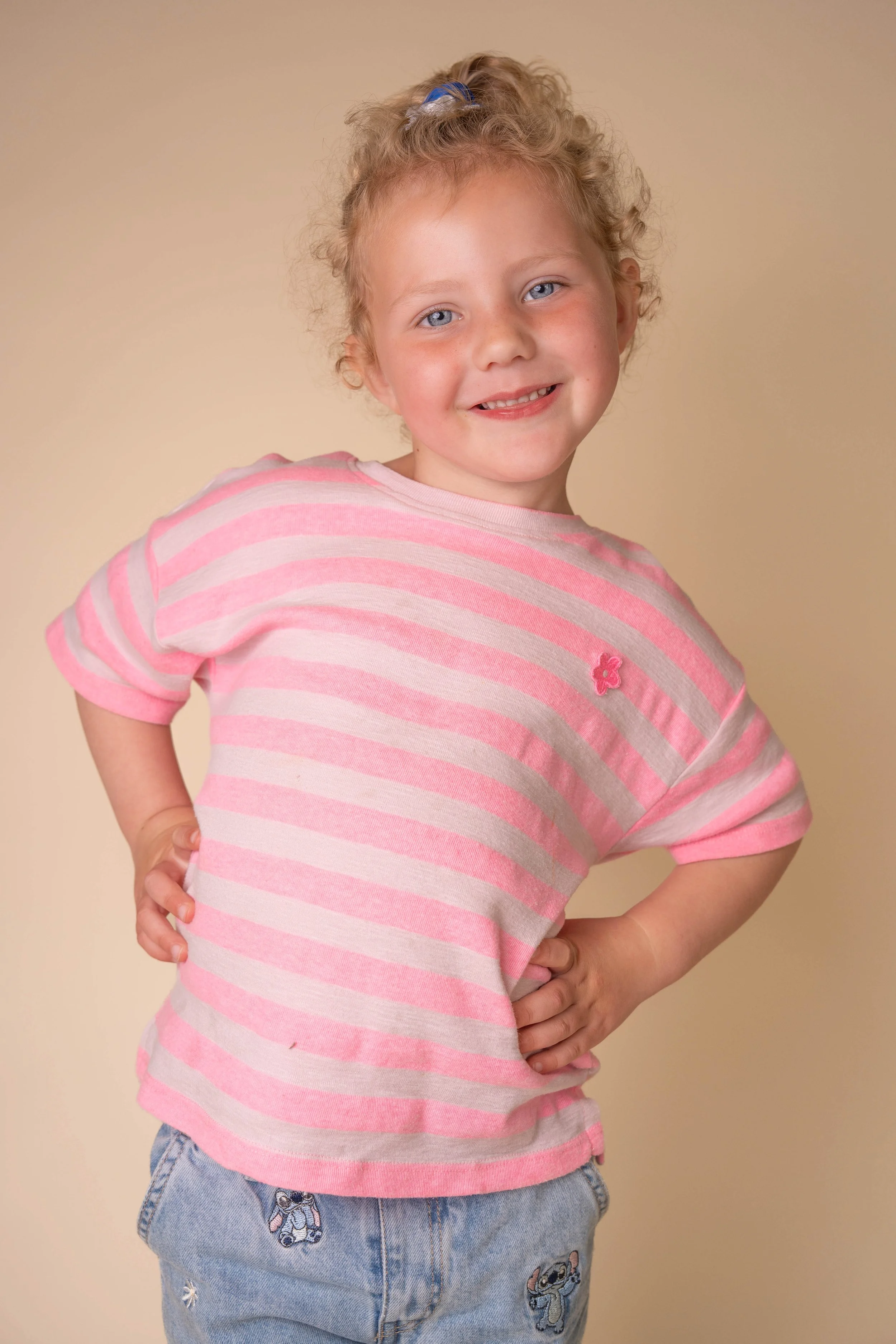 Vrolijk schoolfoto portret van een kind tegen een rustige studioachtergrond.