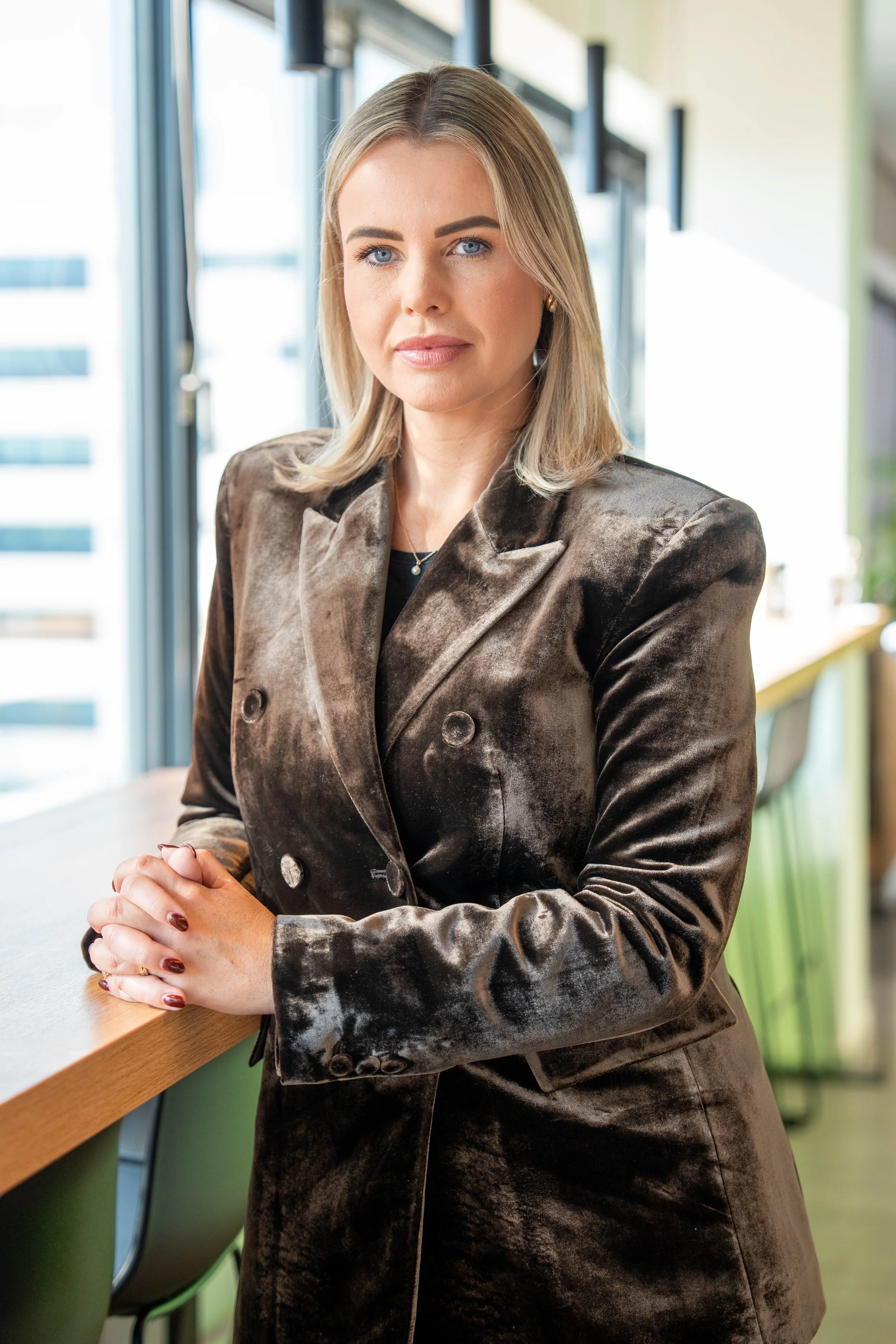 Zakelijk portret van een vrouw bij natuurlijk raamlicht voor personal branding fotografie.