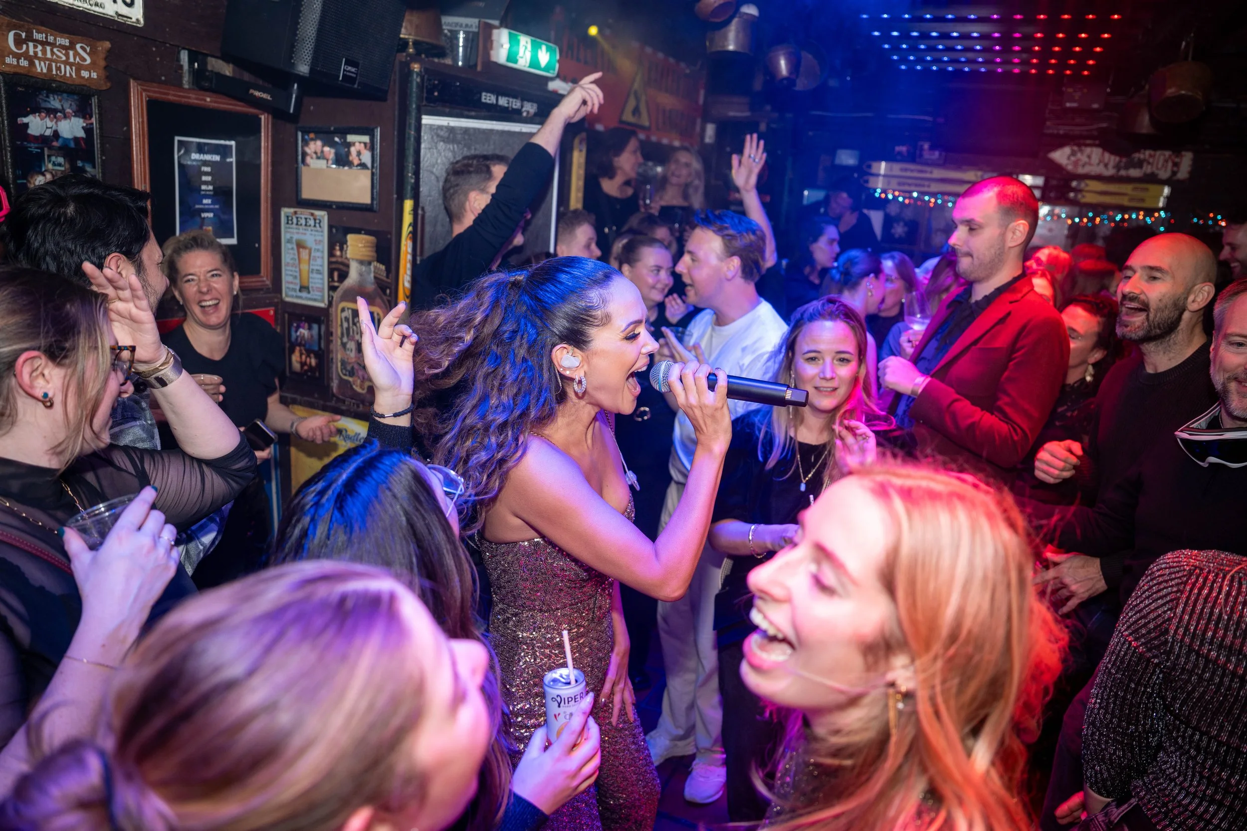 Eventfotografie van een feestelijk optreden met publiek, muziek en dans.