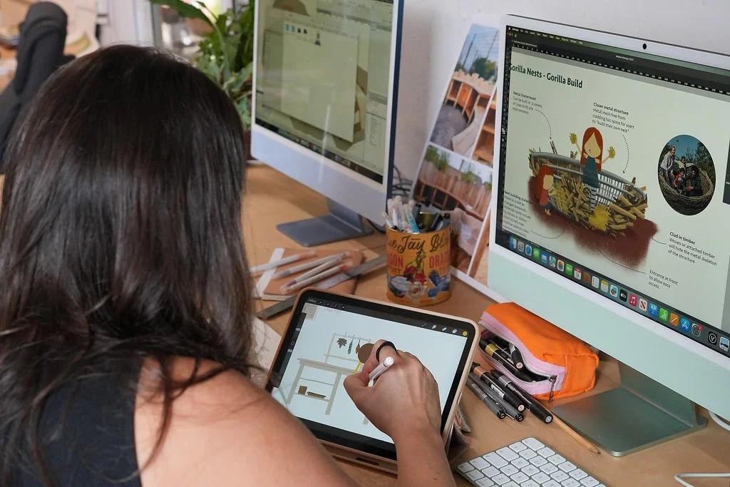 Person working on digital design projects at a desk with computer monitors and drawing tablet.