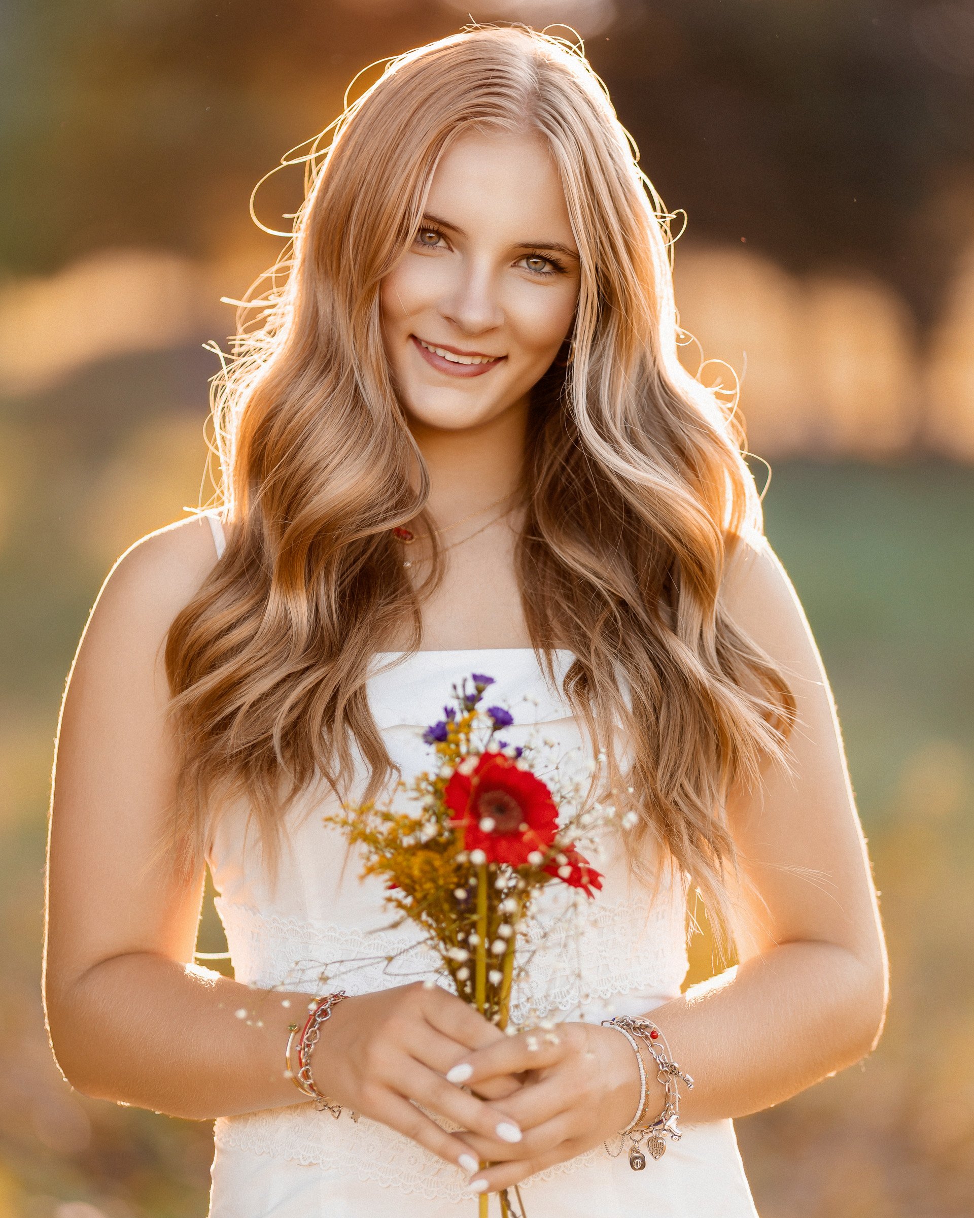 High school senior portrait at golden hour in Dallas Texas with girl holding flowers photographed by rgmphotography