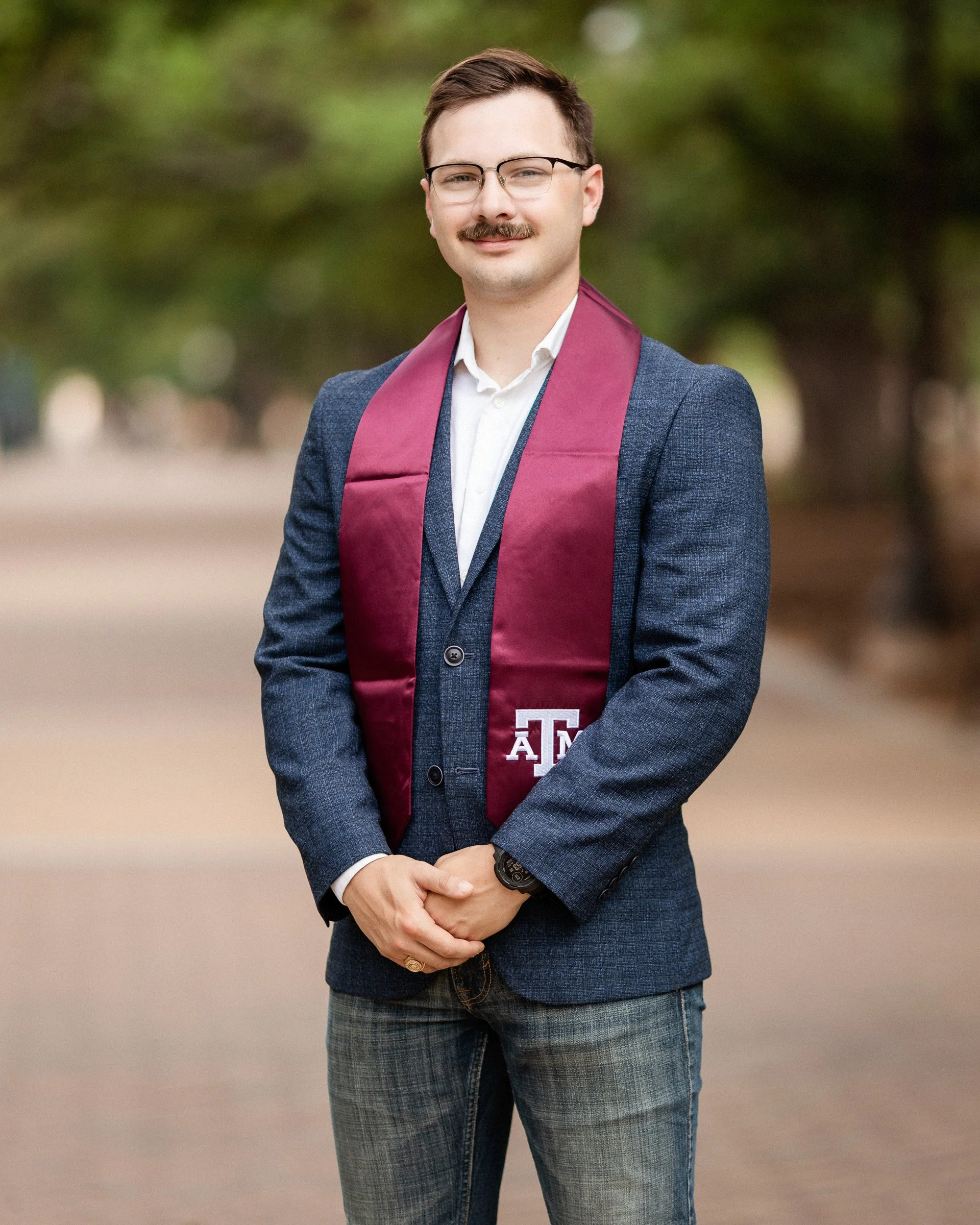 Dallas senior portrait photography male graduate wearing Texas A&M stole during college senior photo session