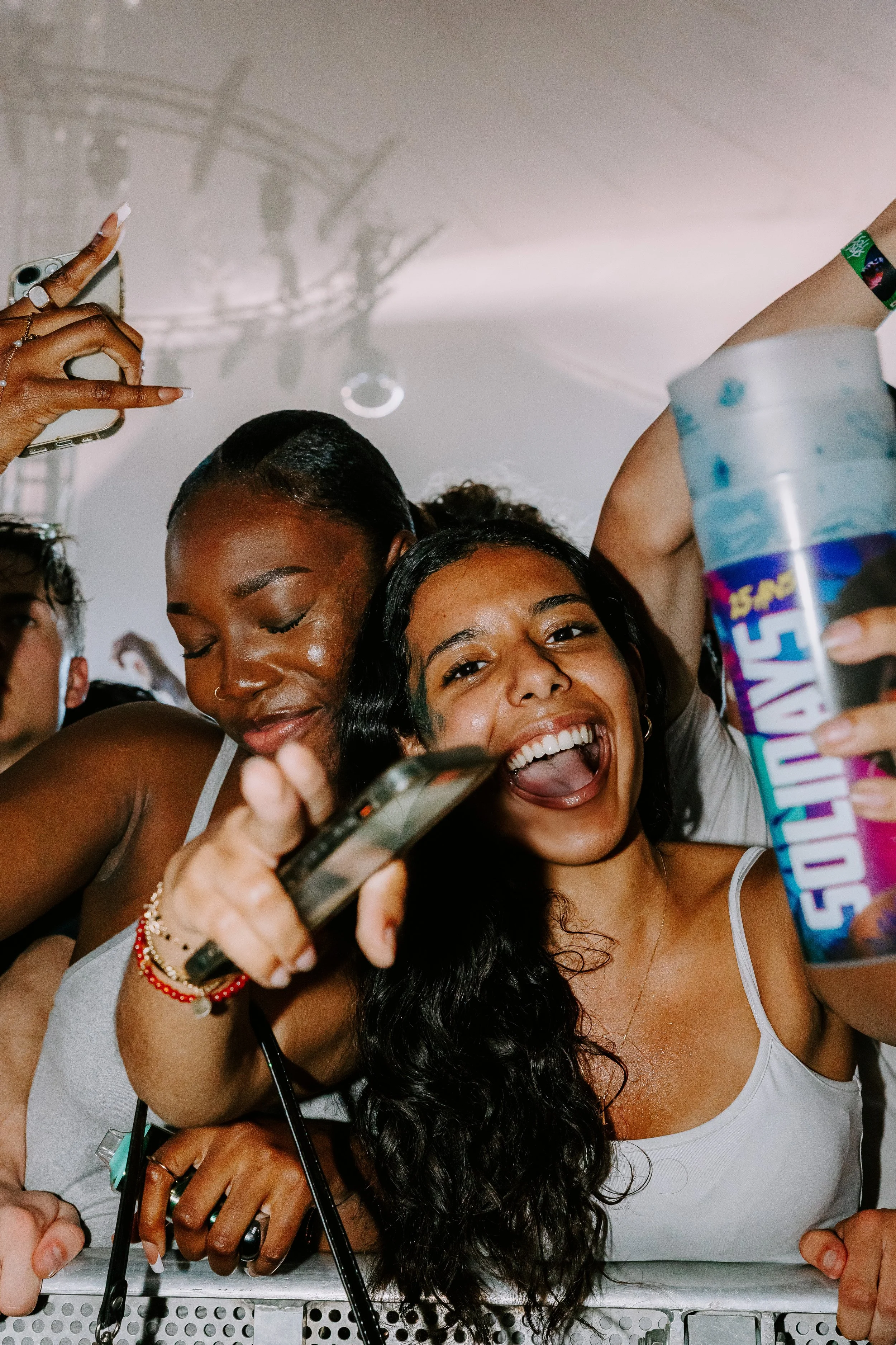 Groupe de jeunes femmes joyeuses au premier rang d'un concert au Festival Solidays.