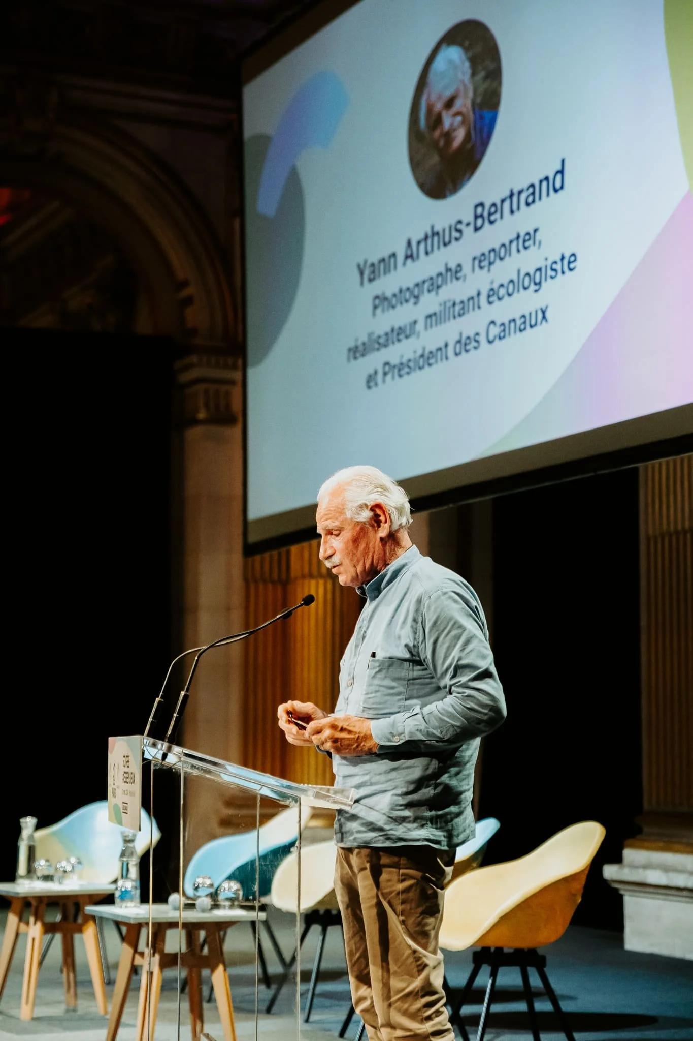 Photo de Yann-Arthus Bertrand qui fait un discours lors de l'événement ESSenJeux de l'association Les Canaux, à l'Hôtel de Ville de Paris.