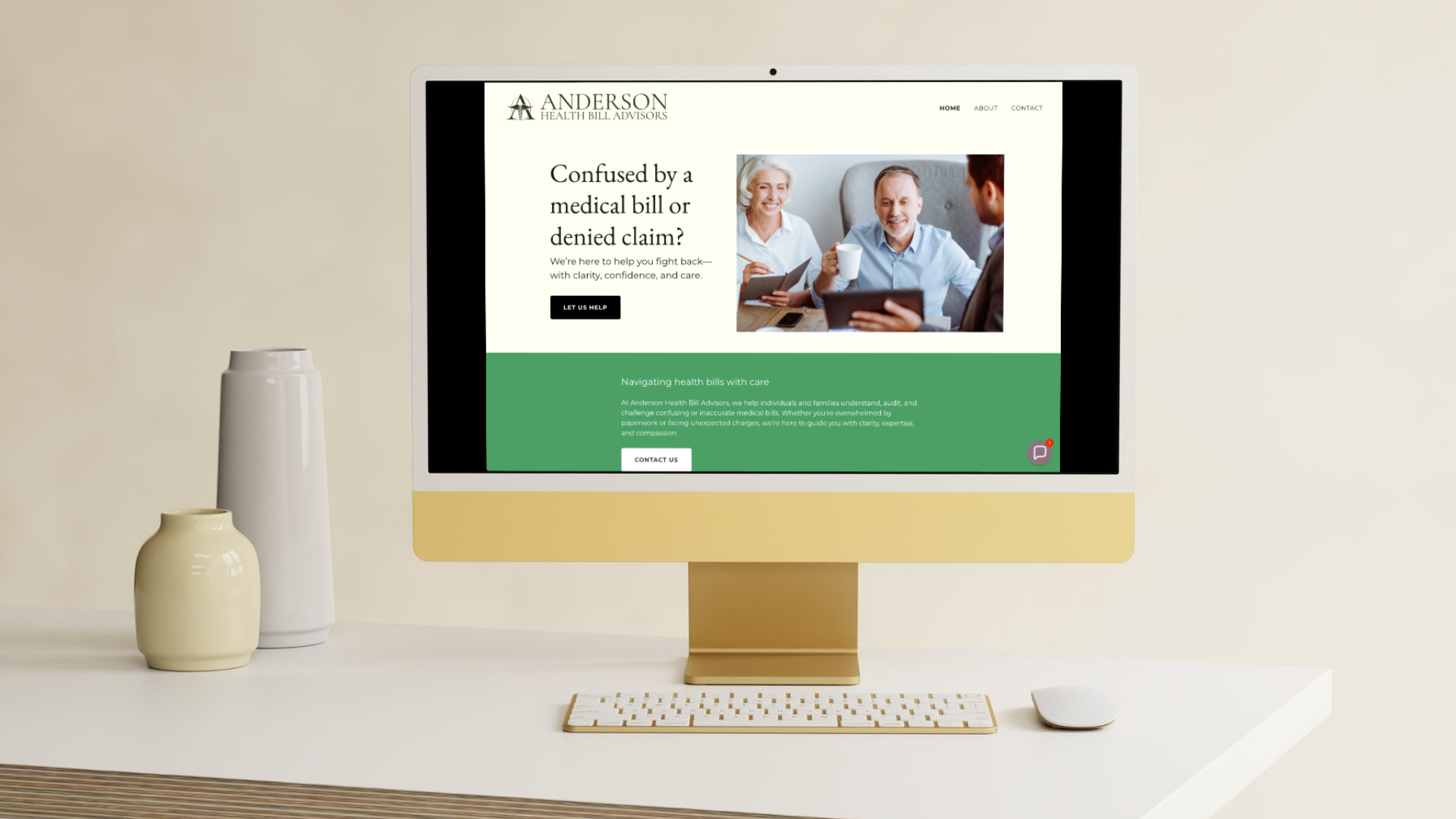 An iMac computer on a white desk displaying a website for Anderson Health Bill Advisors, with a keyboard and mouse in front, and two vases on the left side of the desk.