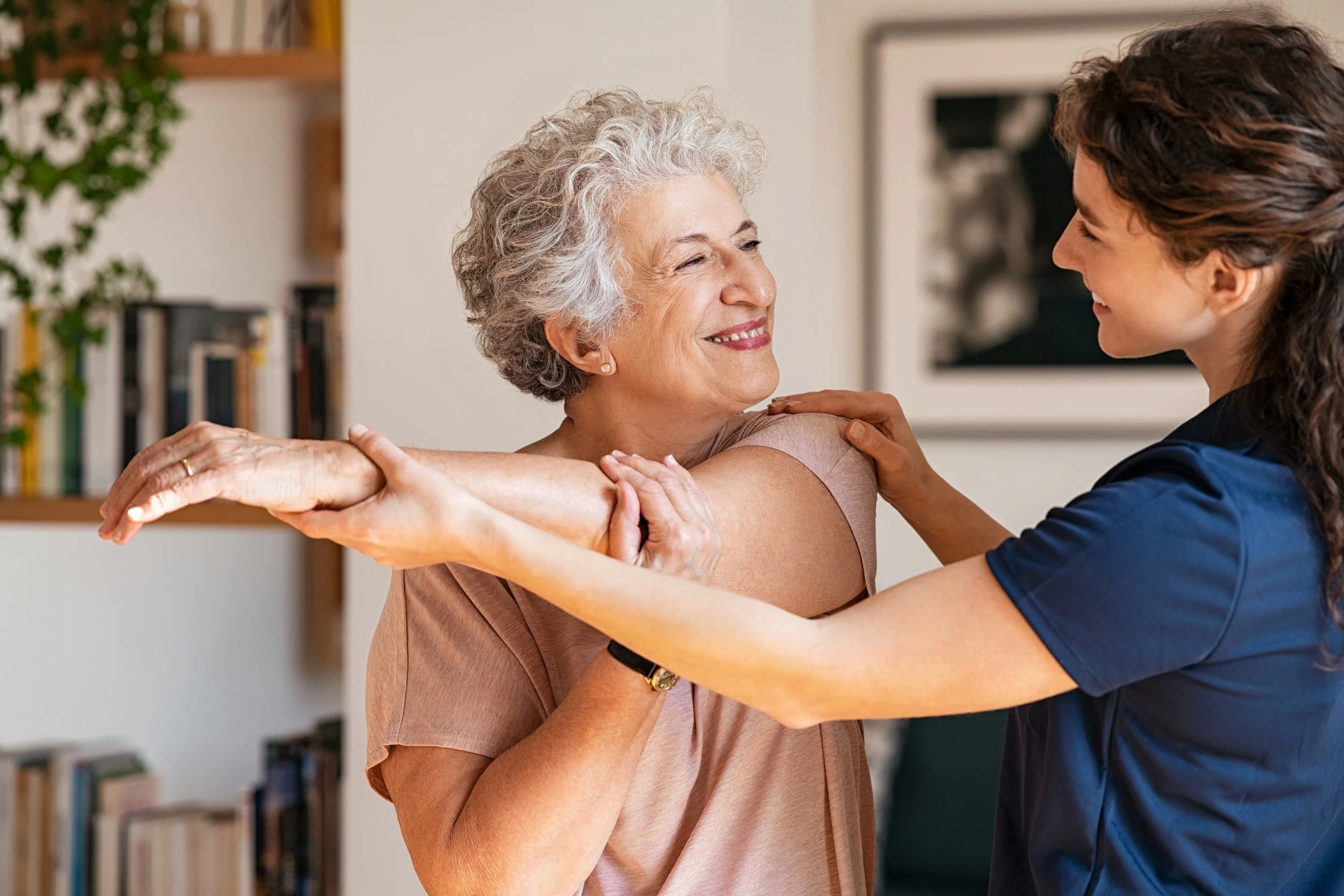 Senior-woman-with-trainer-exercising-at-home-1296176738_3869x2579.jpeg