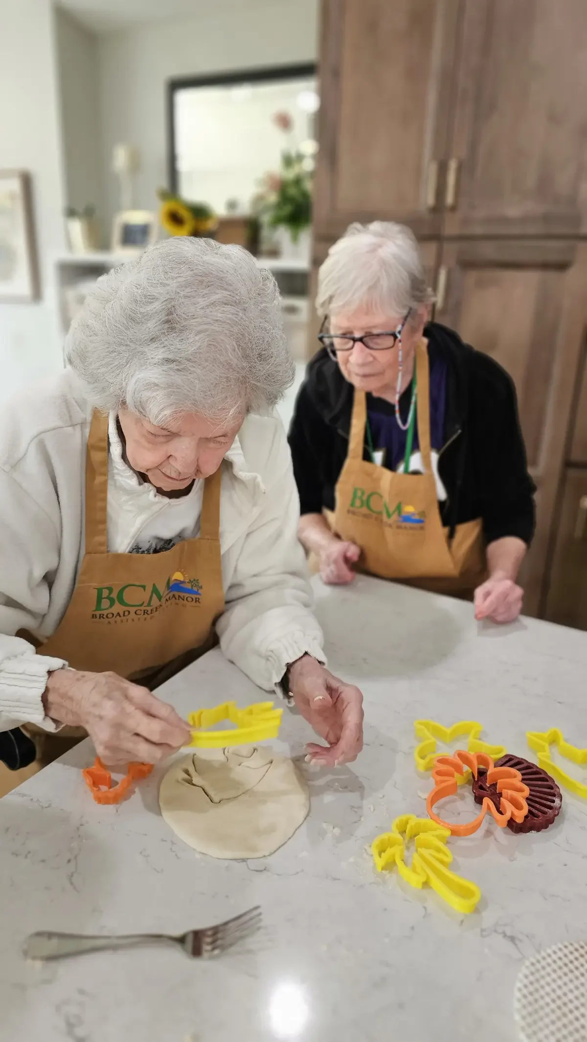 Resident participating in an engaging hands-on activity, supported by staff at Broad Creek Manor.