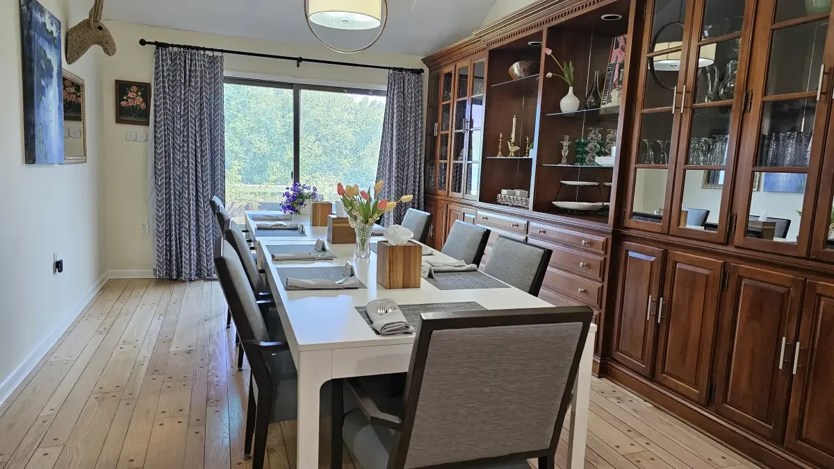 Elegant dining room table at Broad Creek Manor set for residents’ next meal, with bright natural light from the window.