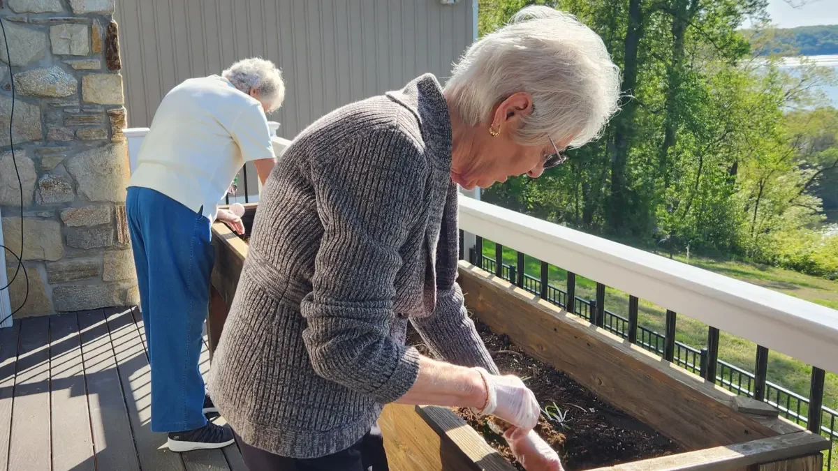 Residents enjoying gardening on the deck overlooking a beautiful view.