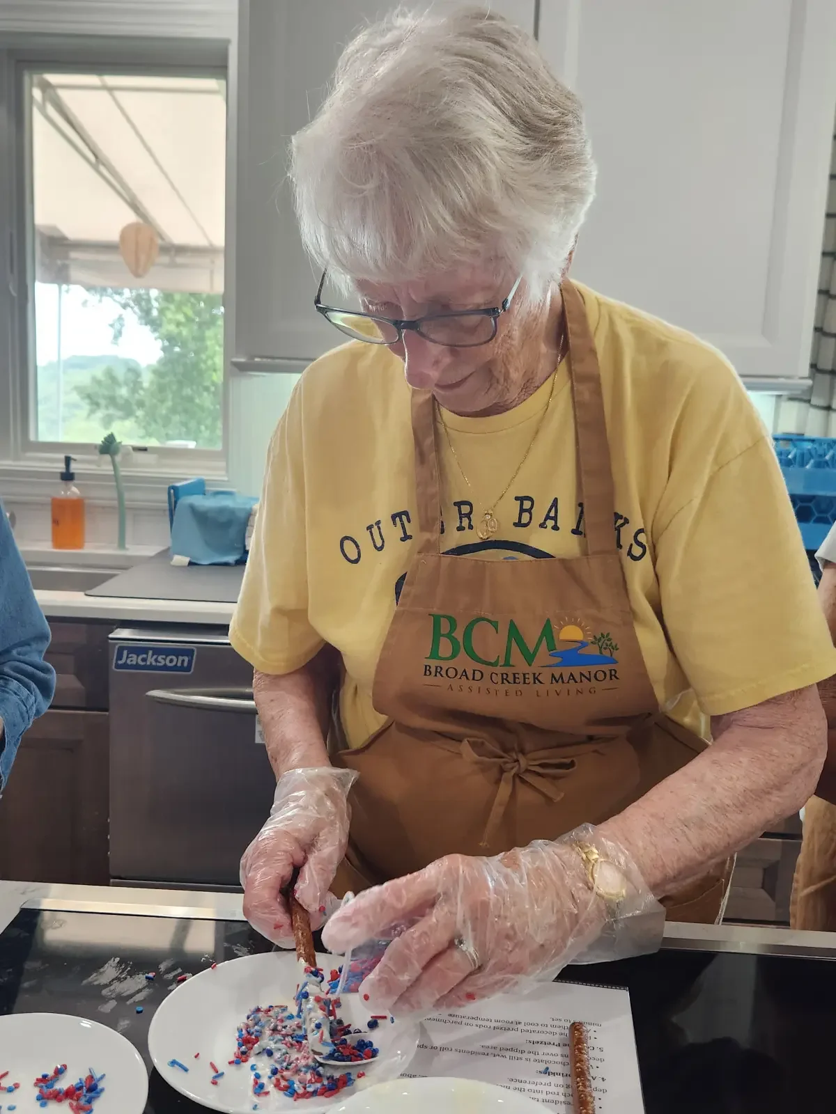 Resident participating in a baking activity at an assisted living.