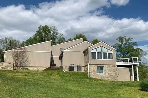 Broad Creek Manor, a residential assisted living community in Northern Harford County, with scenic lawn and modern architecture under a bright blue sky.