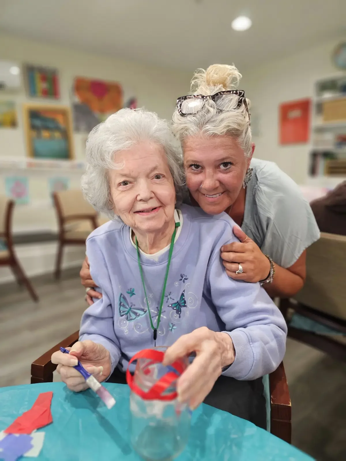 Resident and caregiver smiling together while sharing a joyful moment at Broad Creek Manor