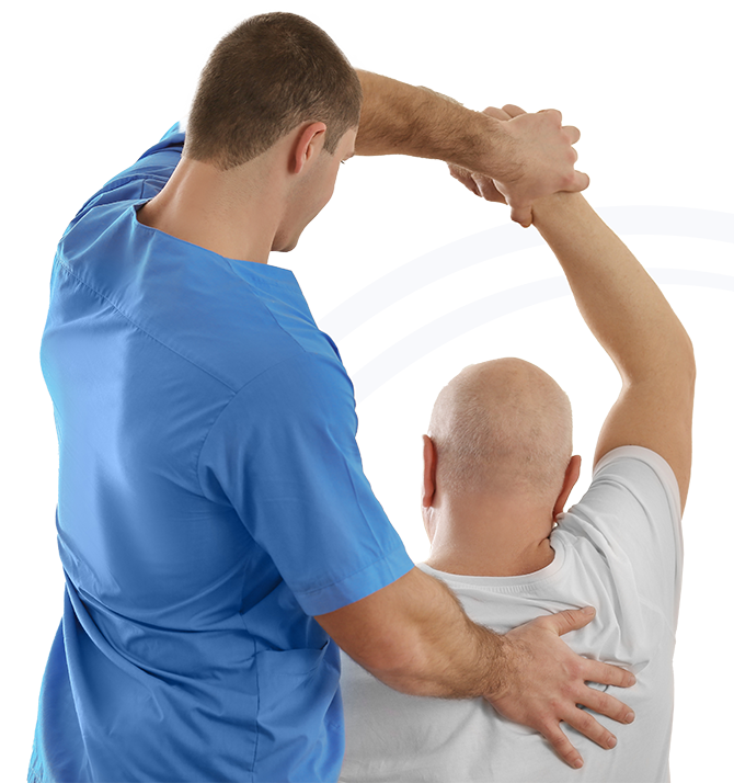 A physical therapist or trainer in blue scrubs assists a patient with a shoulder stretch, holding the patient's arm overhead.