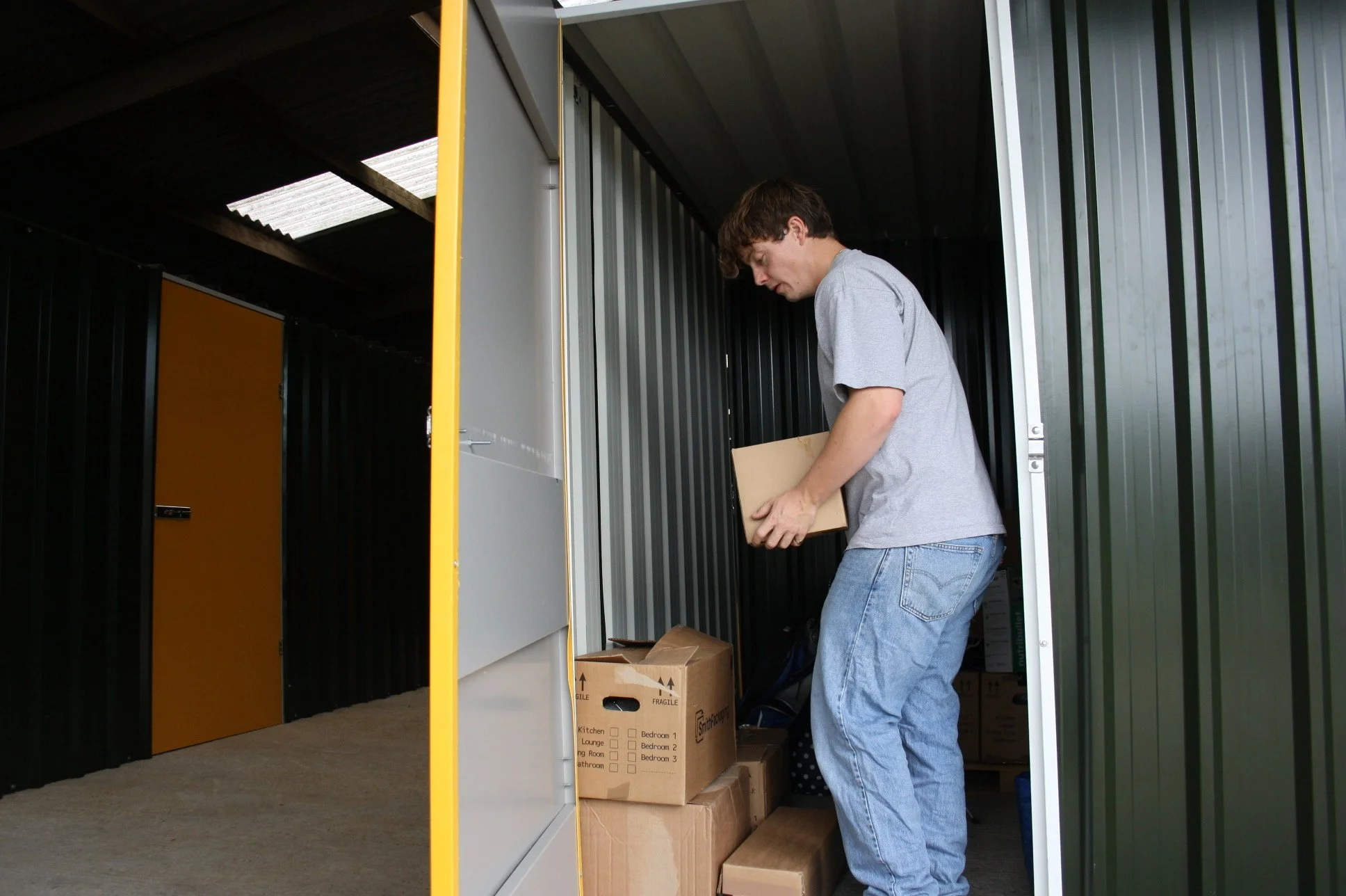 A man organizing boxes inside a storage unit