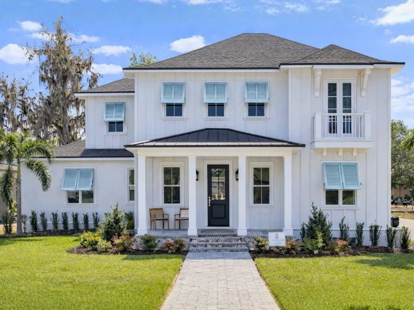 large white home with long walkway and perfect landscaping plants, grass and trees. 