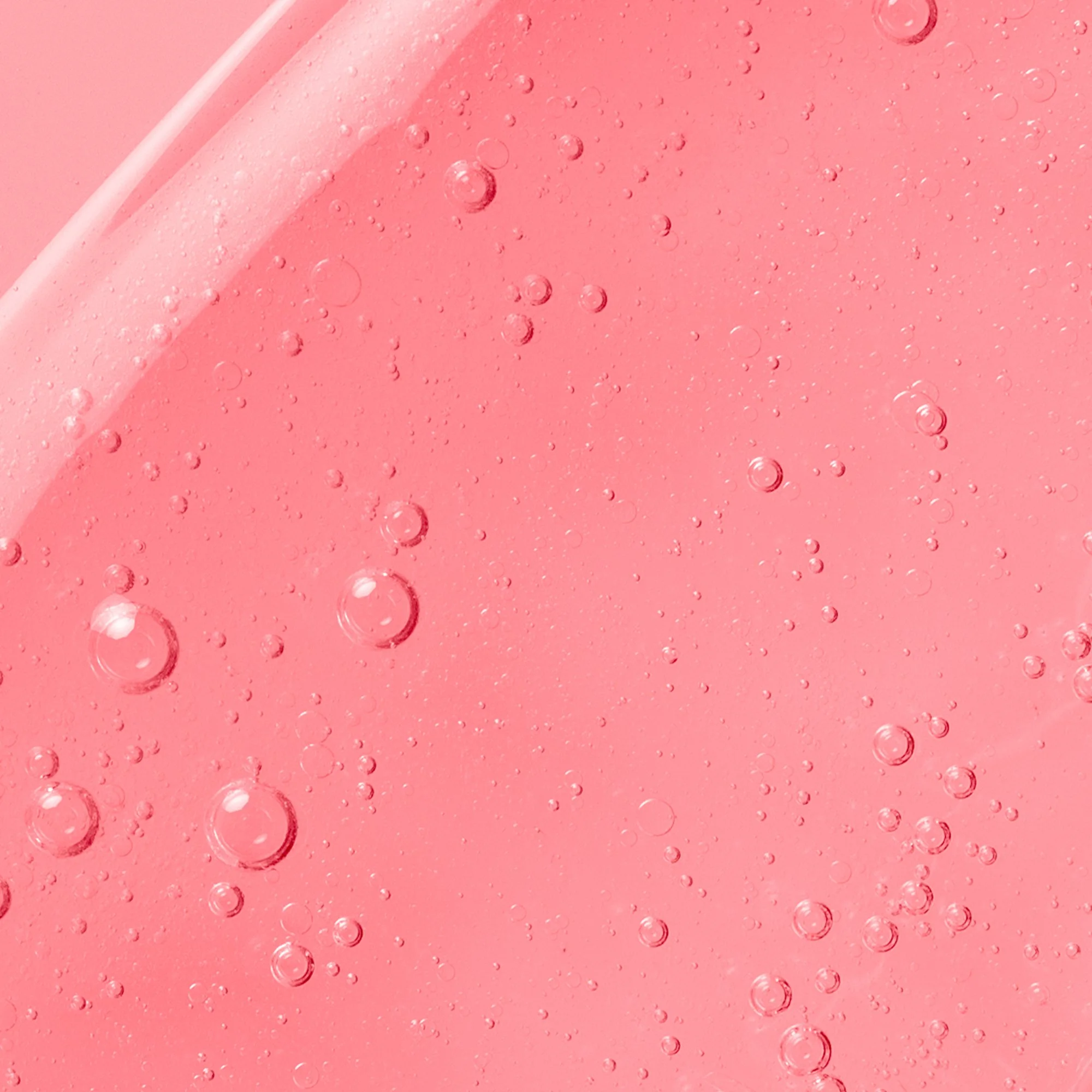 Close-up of pink liquid with bubbles, possibly a bubbly drink or soap.