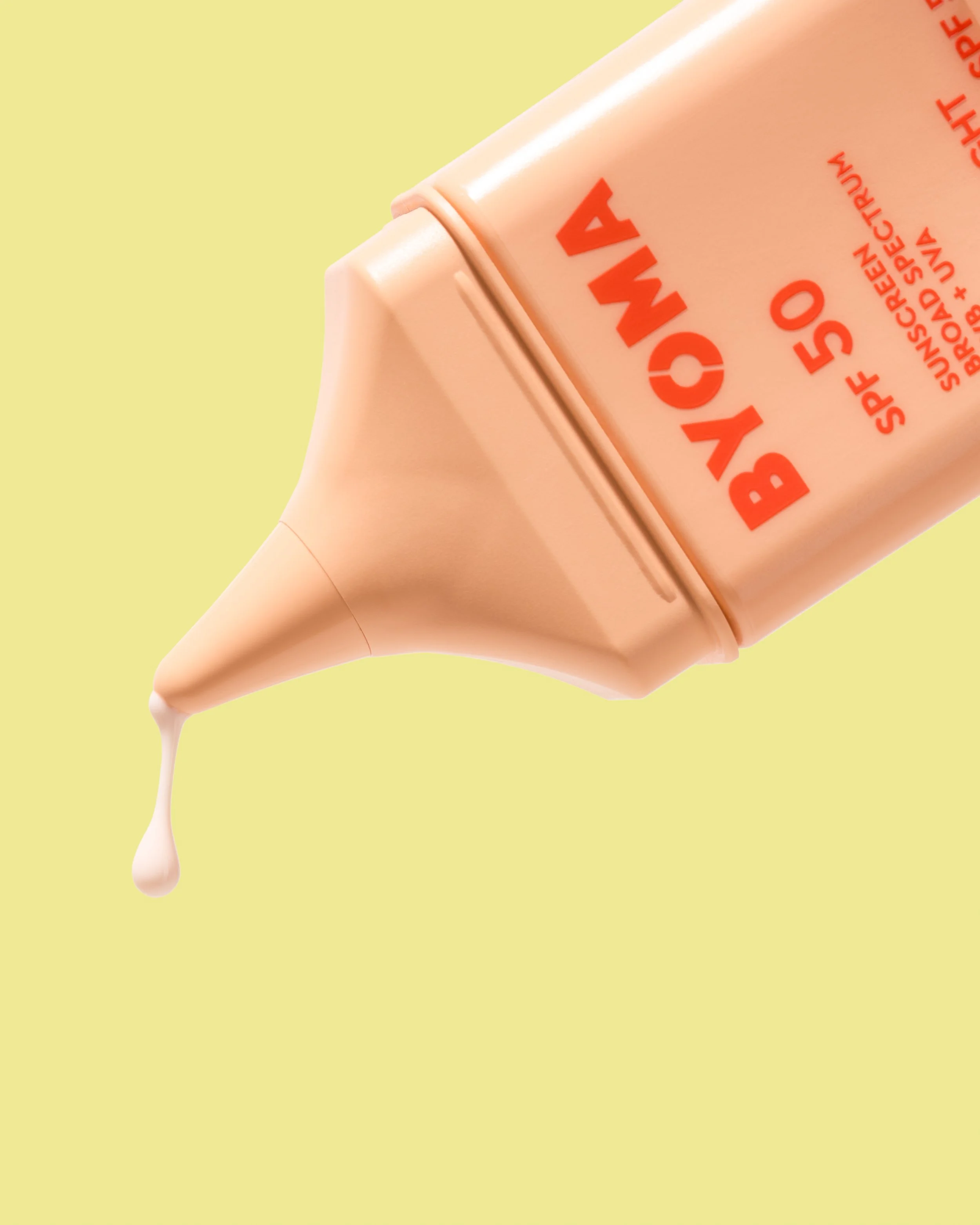 A bottle of BYOMA cream SPF 50 with a small amount of cream dripping from the nozzle against a yellow background.