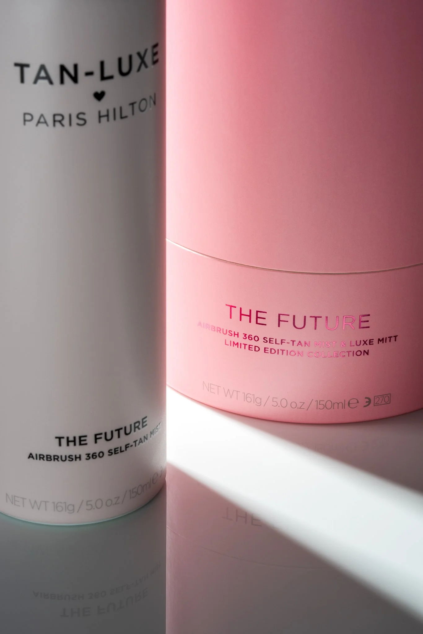 Close-up of two limited edition skincare products, one in a white container and the other in a pink container, with sunlight casting a shadow.
