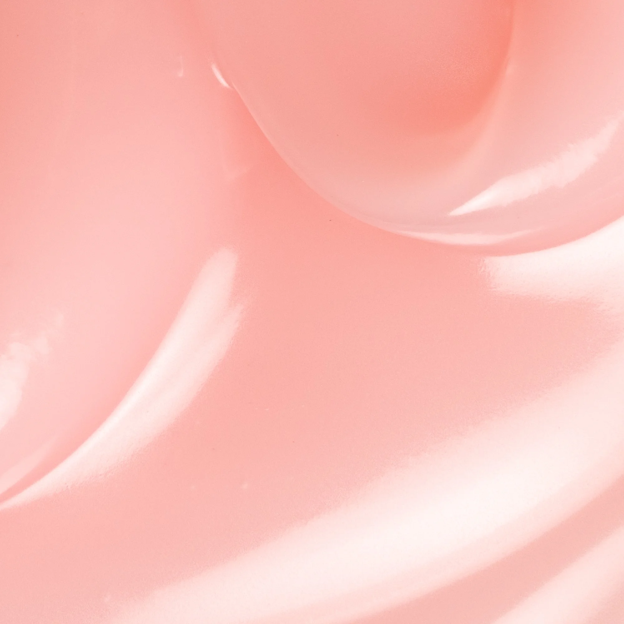 Close-up of a pink, glossy, pouch or bag with rounded edges and shiny surface.