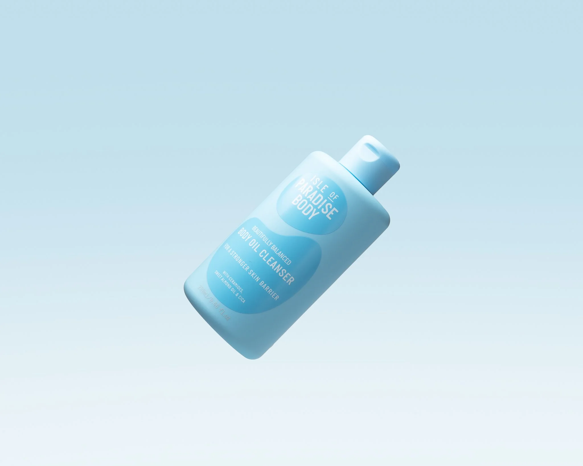 A bottle of Isle of Paradise body oil cleanser floating against a light blue background.