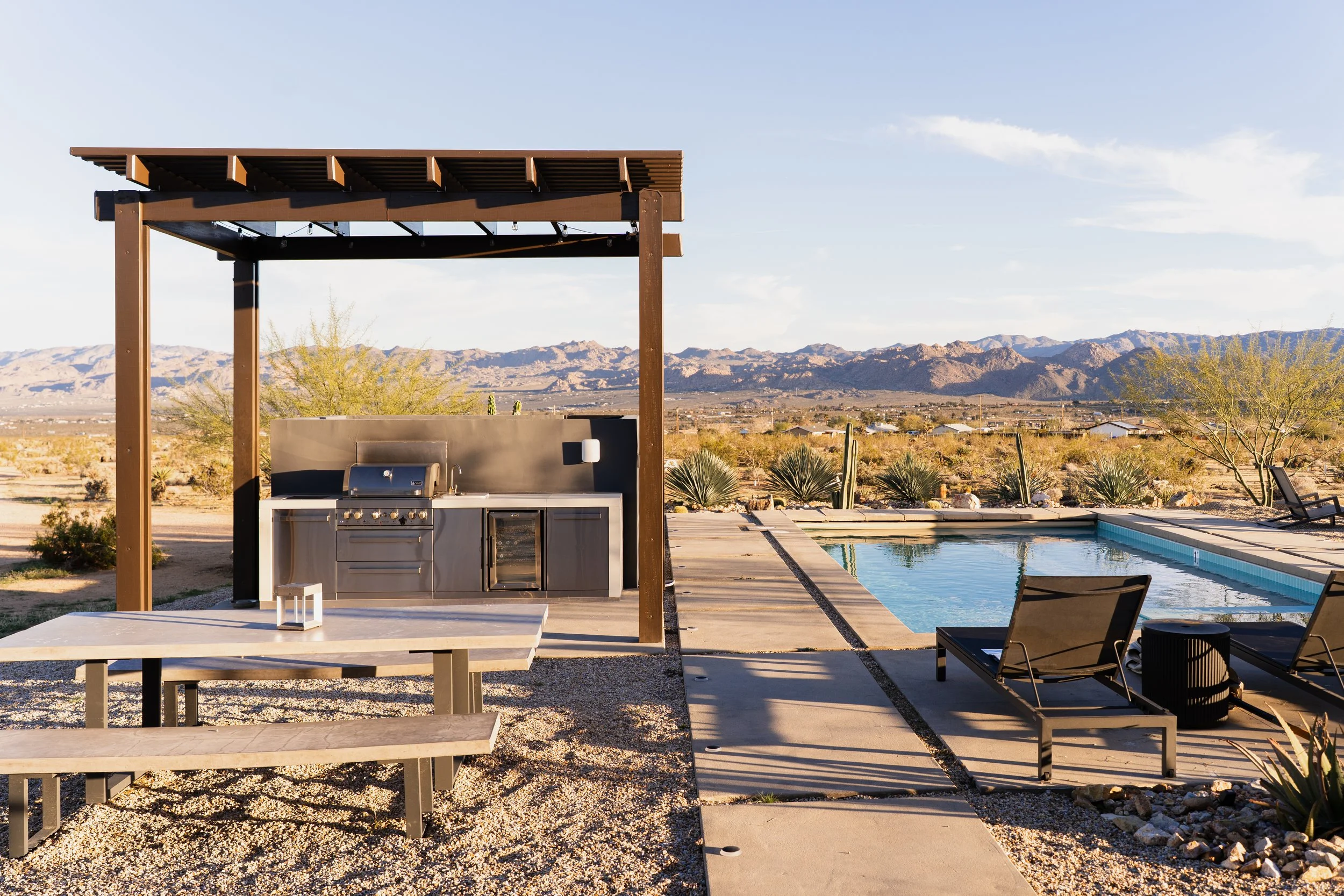 Modern outdoor kitchen with large dining table. 
