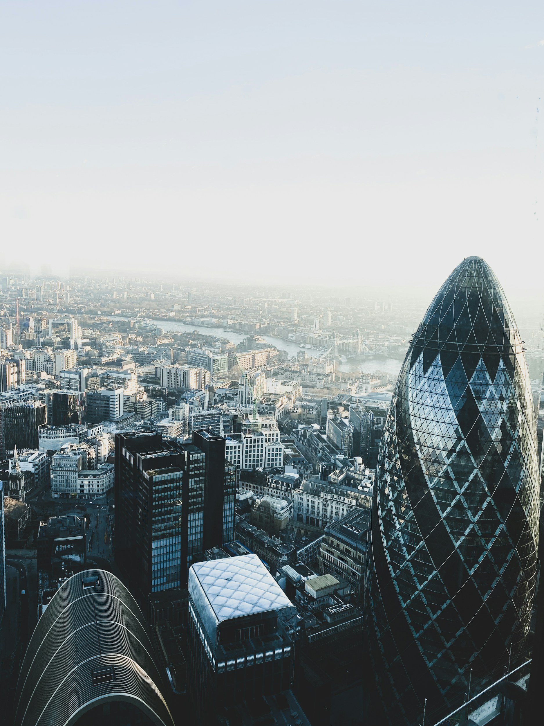 Aerial view of London skyline featuring the Gherkin building with the River Thames in the background.