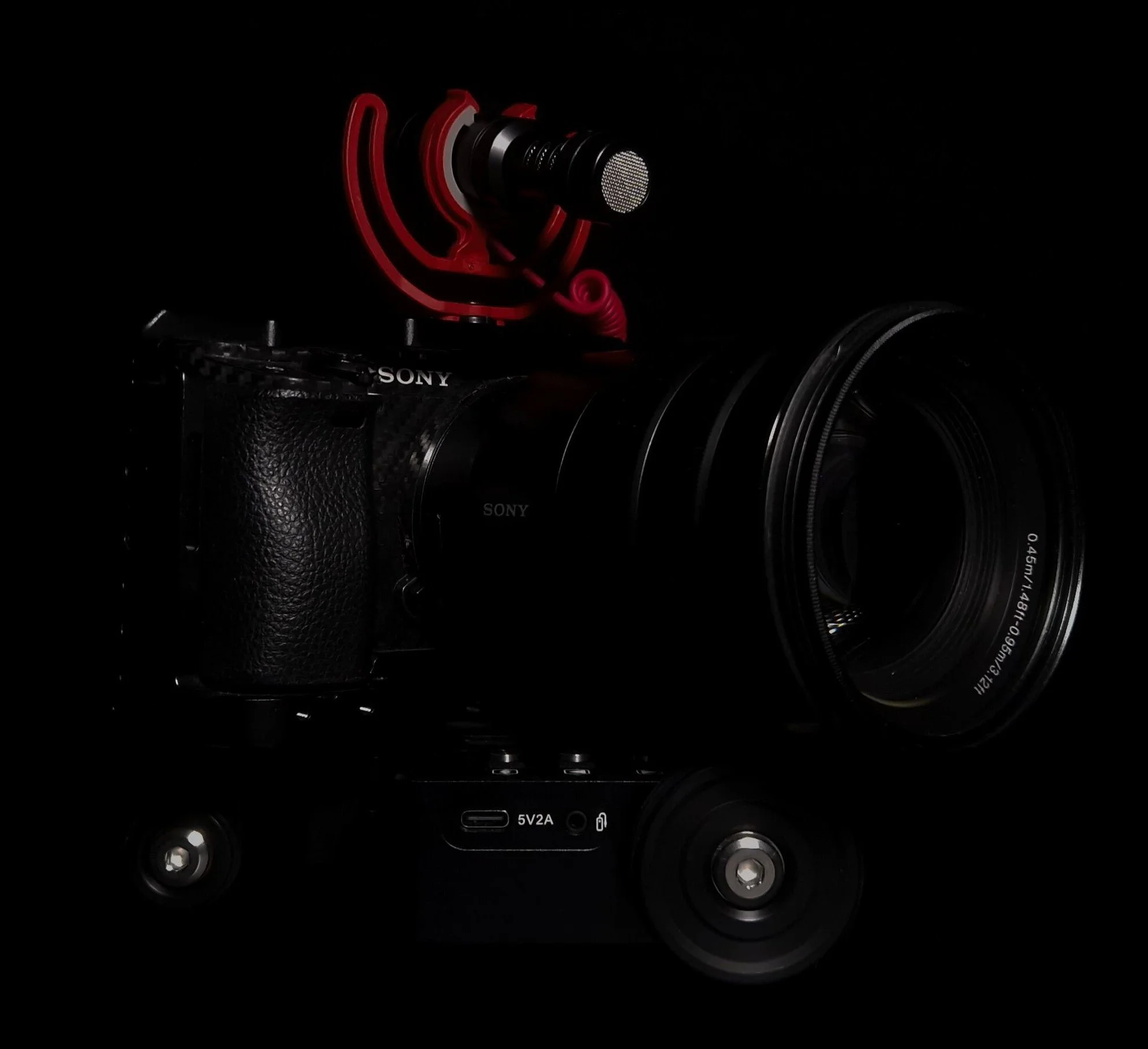 Professionelle Kamera mit Mikrofon auf Slider, schwarzer Hintergrund.