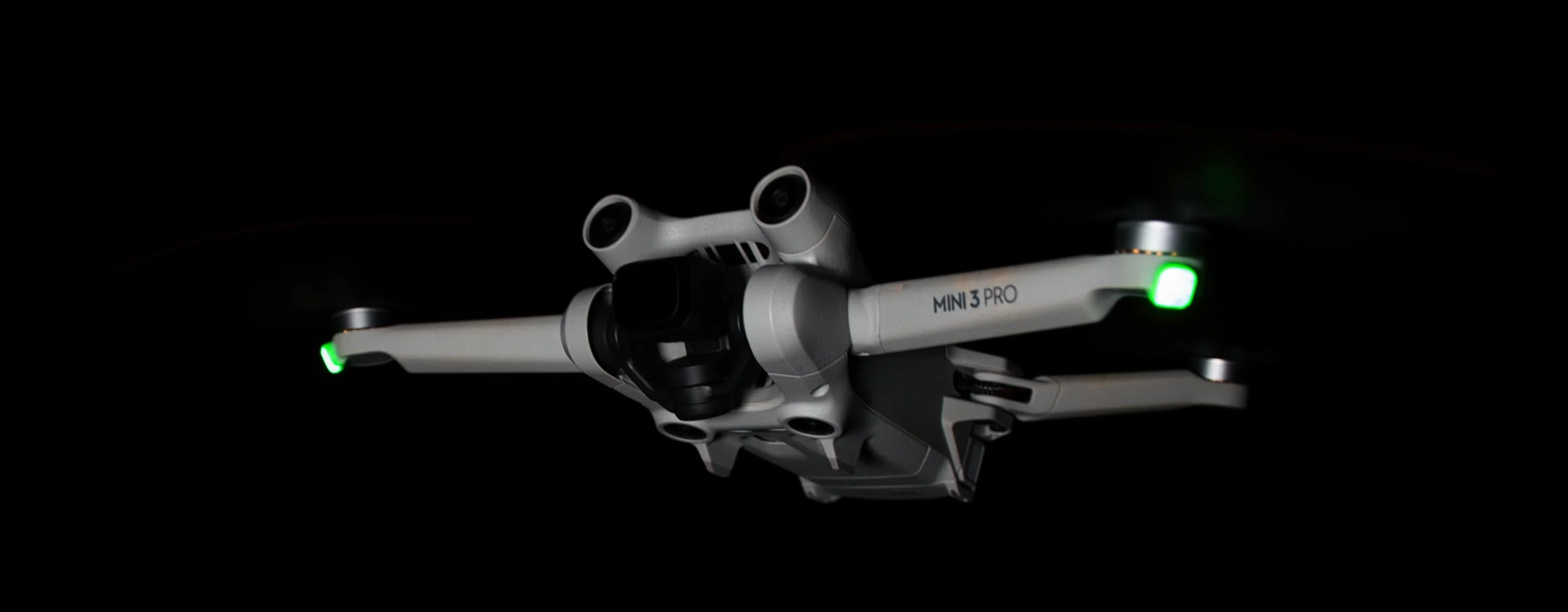 Drohne im Flug, Dunkelheit, leuchtende grüne Lichter an den Flügeln, Mini 3 Pro