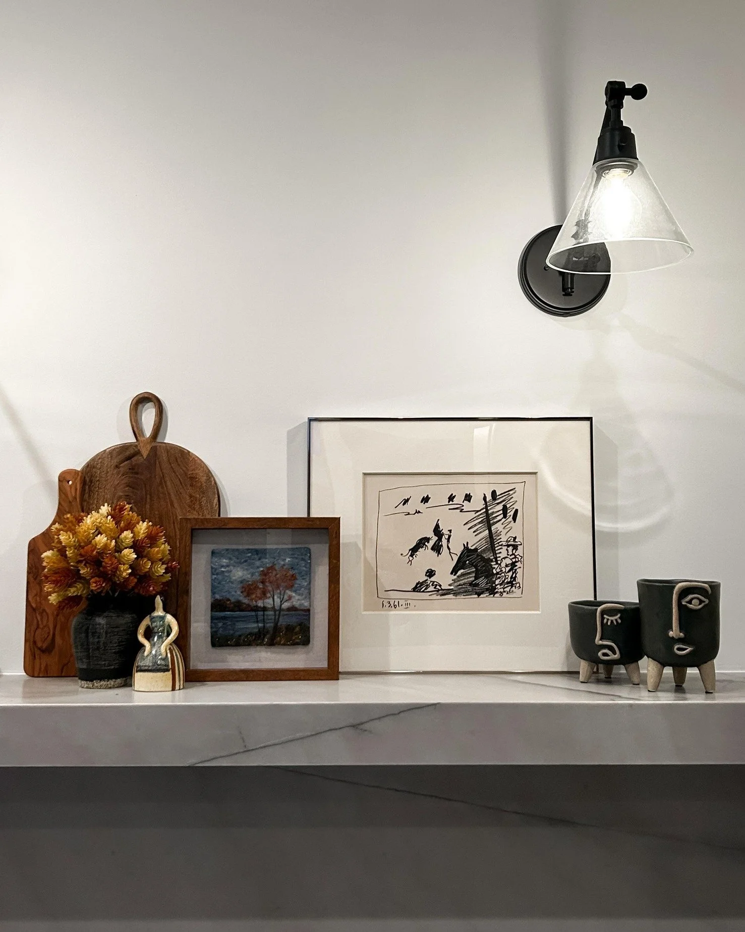 Old meets new. Beauty meets purpose. Every detail intentional.

This floating shelf was designed to handle real weight, layered with meaning, and styled with pieces that tell a story. Wool art beside a gifted Picasso lithograph. An antique cutting bo