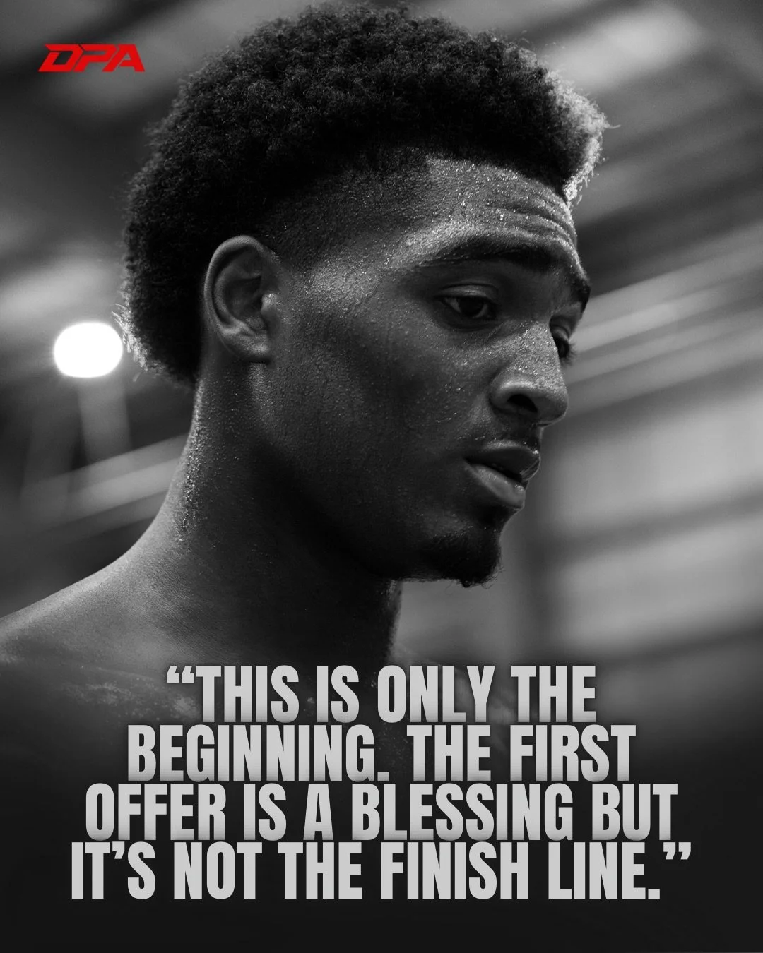 Black and white photo of a young man with short textured hair, looking downward with a thoughtful expression, sweat on his face, in a gym or training environment. A motivational quote overlays the image: "This is only the beginning. The first offer is a blessing but it’s not the finish line."