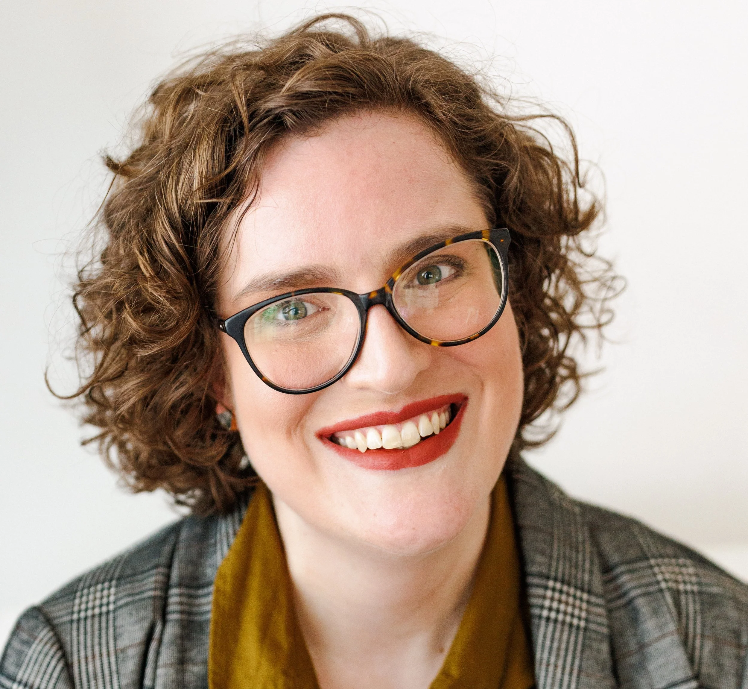 Melissa, a white person with brown hair and glasses smiling