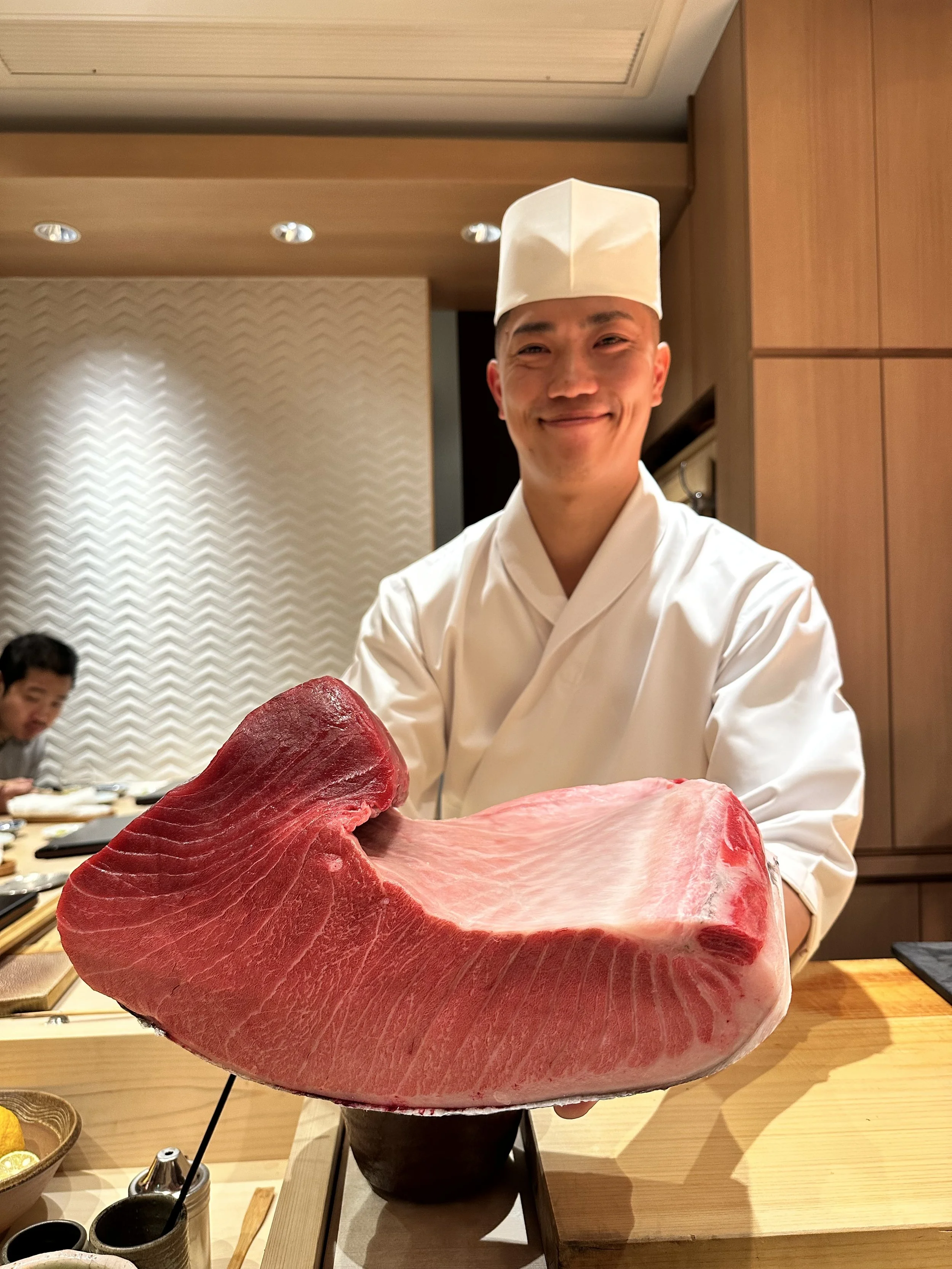 Akira Sushi Tokyo holding fresh tuna piece.jpeg