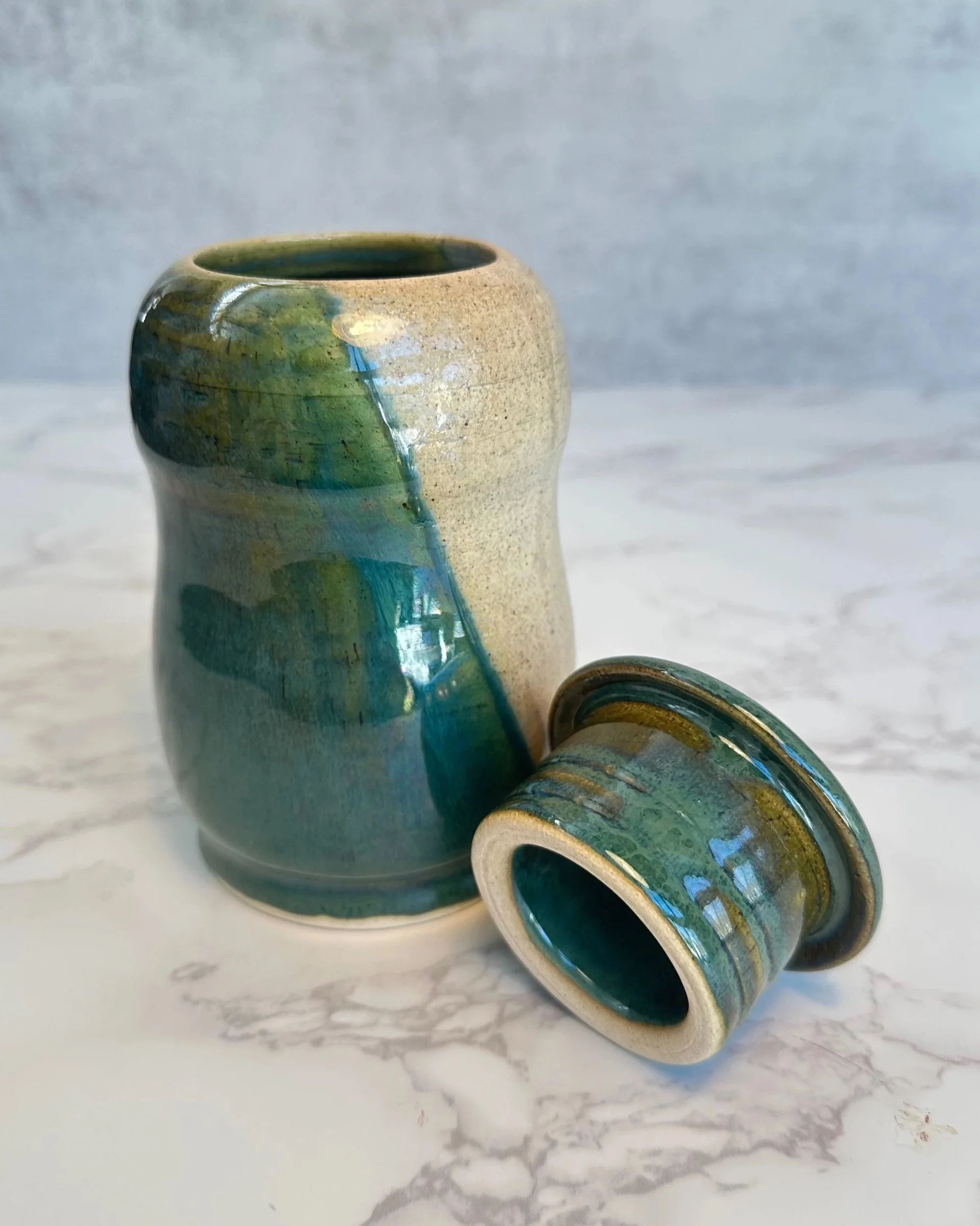 Wheel thrown lidded jar with penguinesque form and layered emerald green glaze by Tabula Rasa Clay.