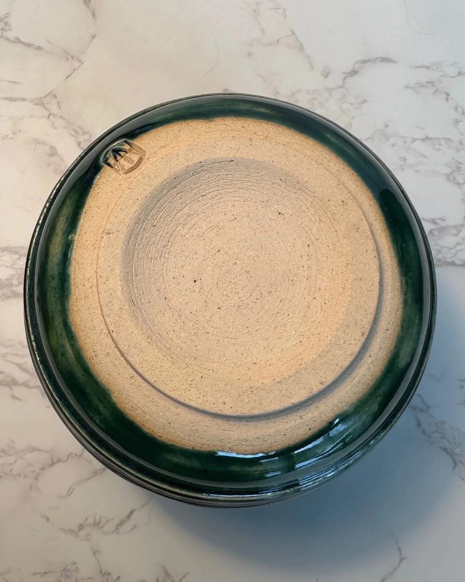 Bottom view of wheel-thrown vase in blue and green striations