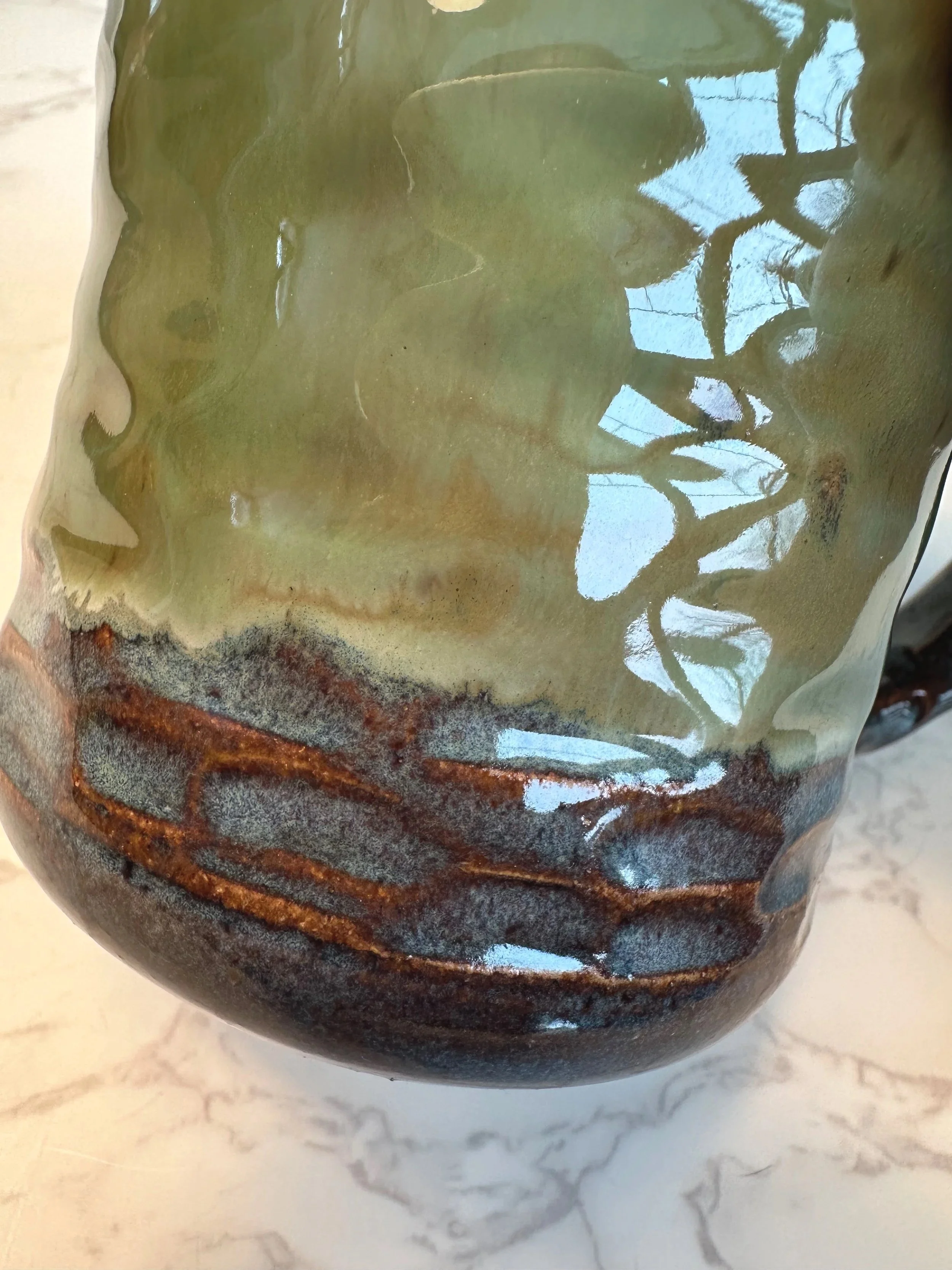 Close up of Handmade ceramic mug in rustic green glaze, 11 ounce stoneware mug