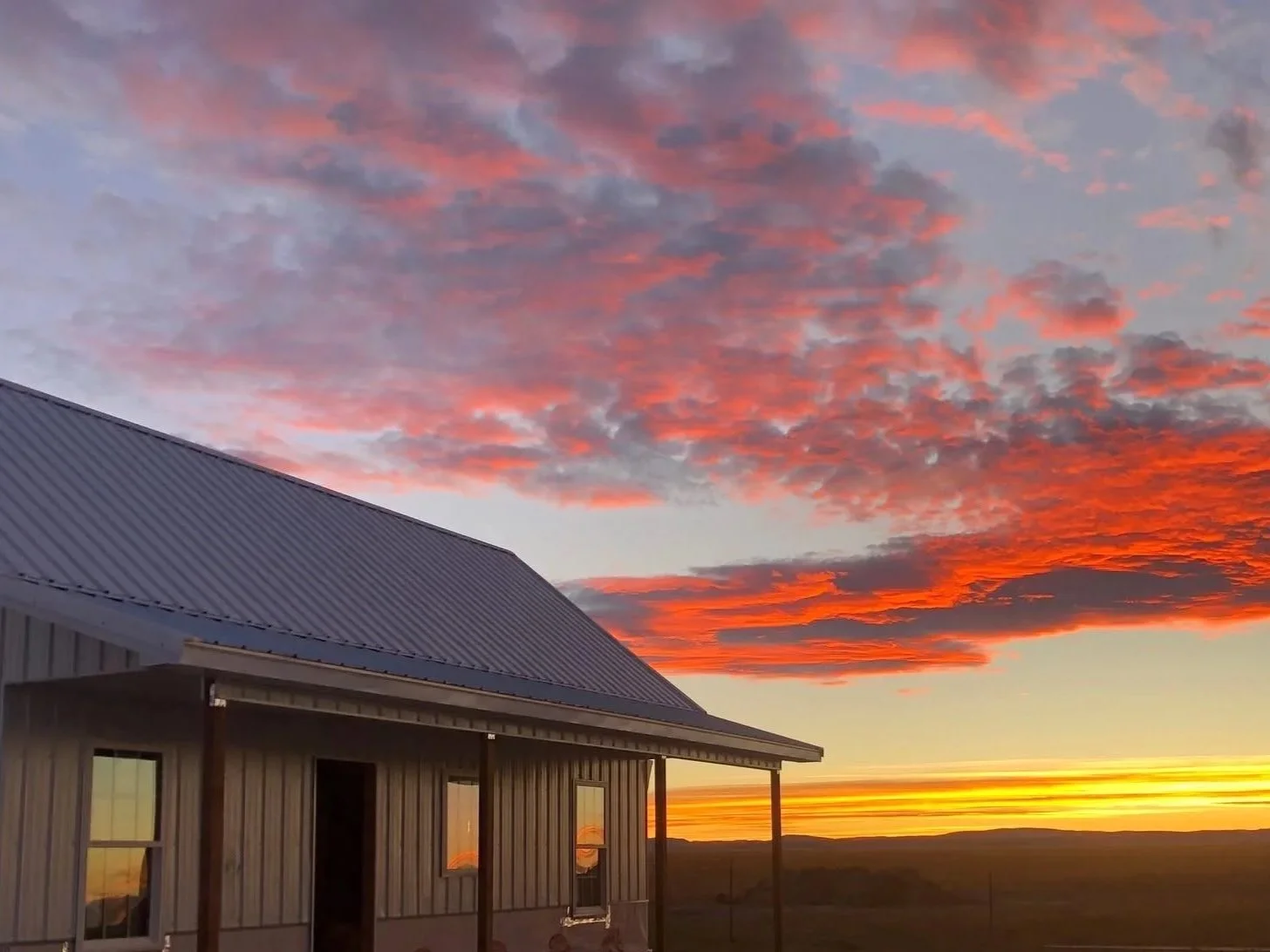 A small White House with a beautiful pink sunset behind it