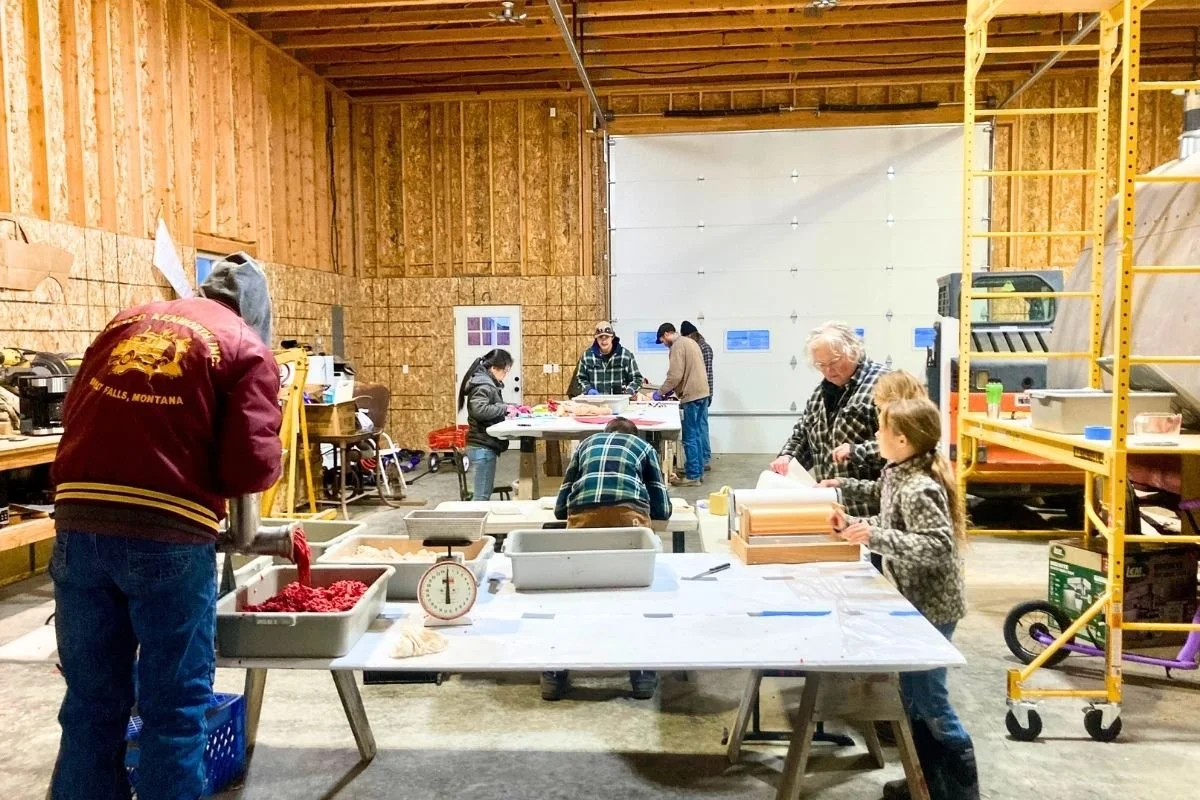 A group of people cut up a beef in a shop