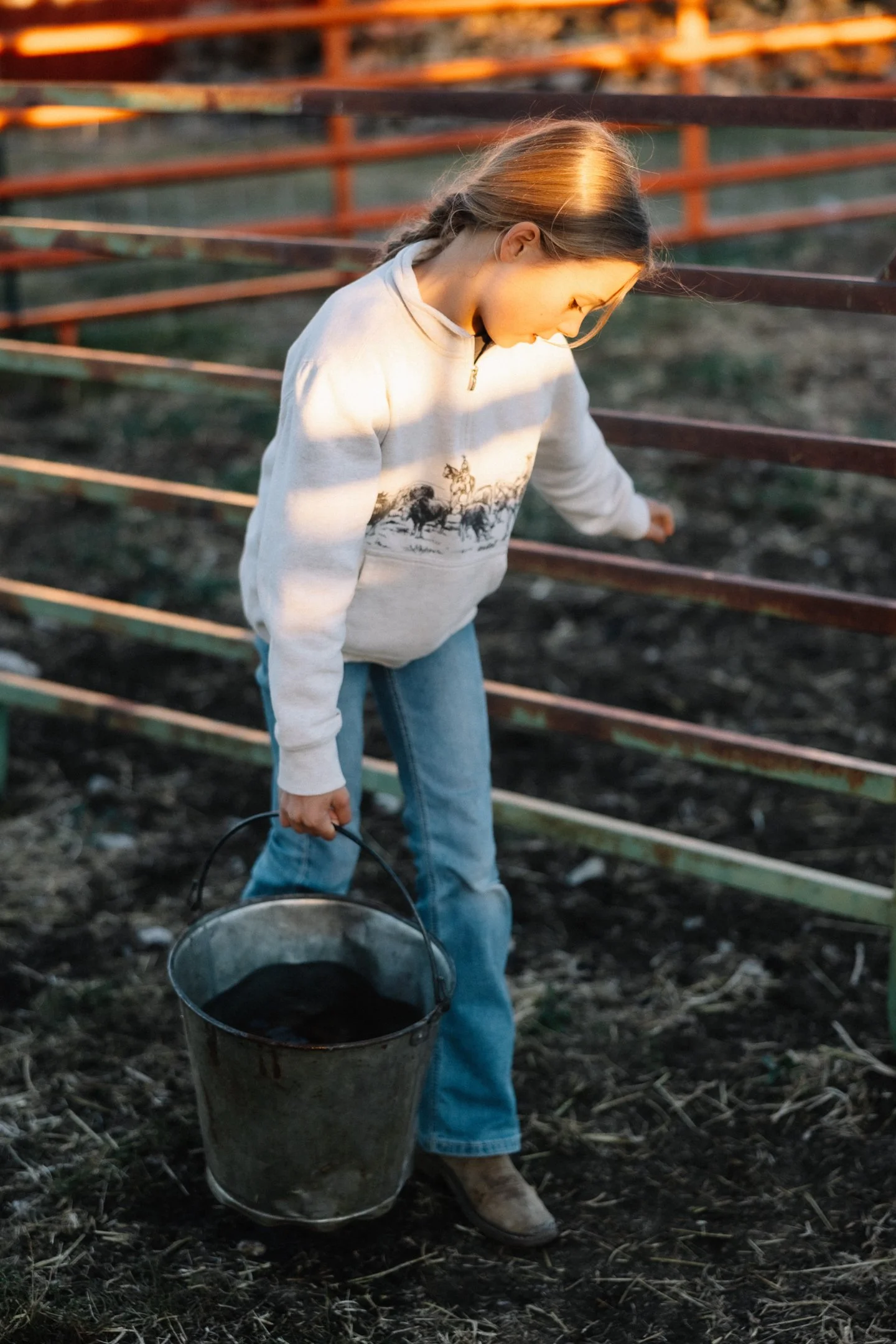 a young girl packs a bucket of water