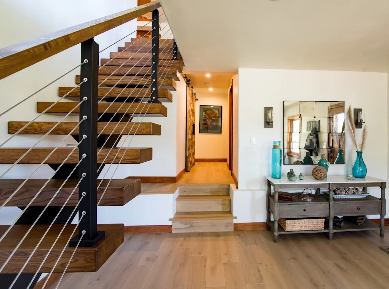Oak hardwood flooring and custom wood staircase with cable railing in Malibu, CA